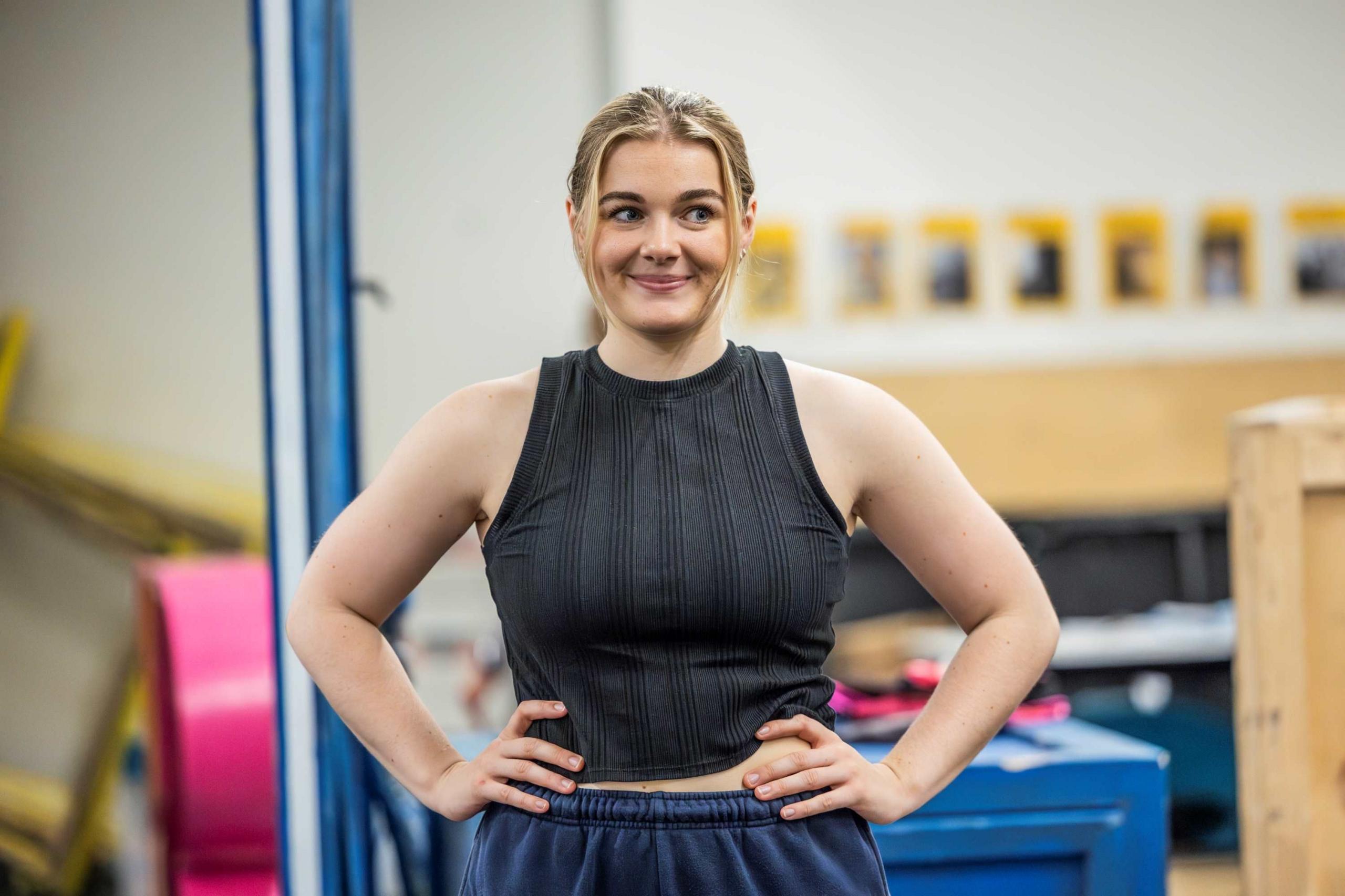 Meg Hateley in rehearsal wearing a ribbed black vest and navy blue trousers