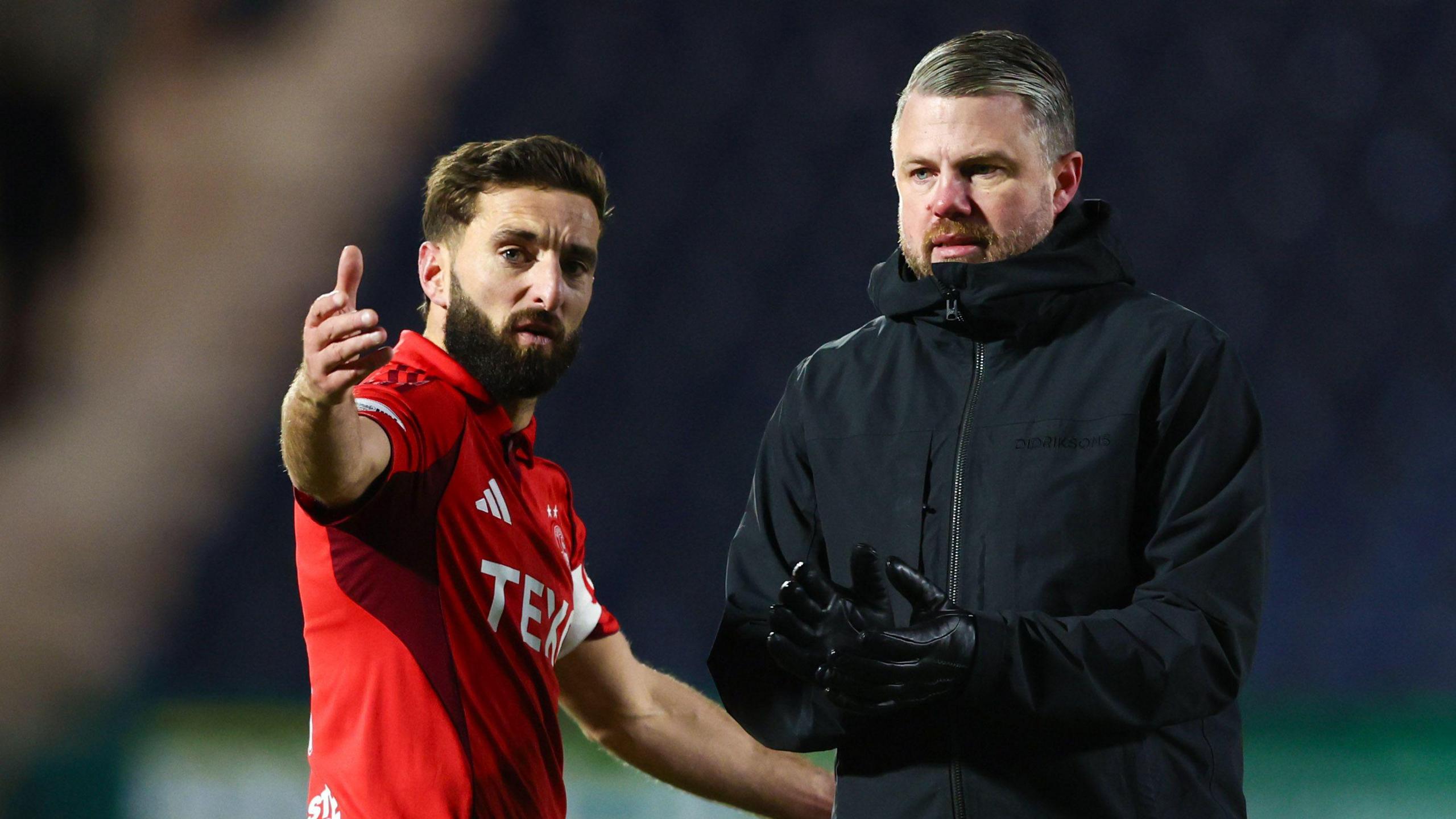 Graeme Shinnie gestures while stood next to Jimmy Thelin