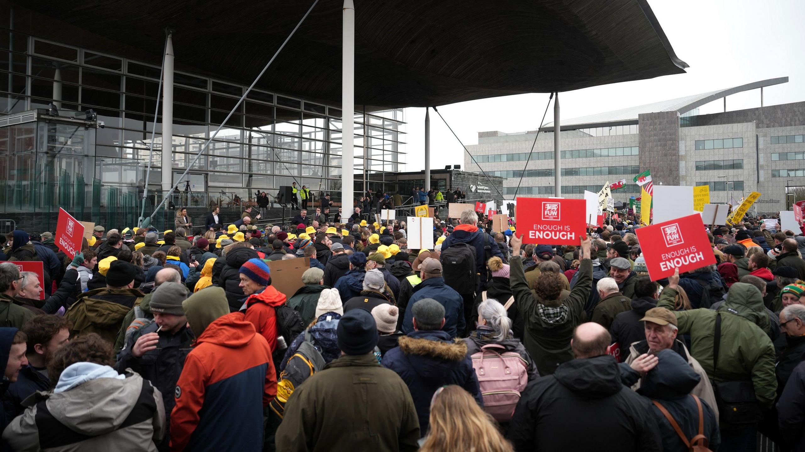 Protesters holding placards gather outside the Senedd on February 28, 2024.
