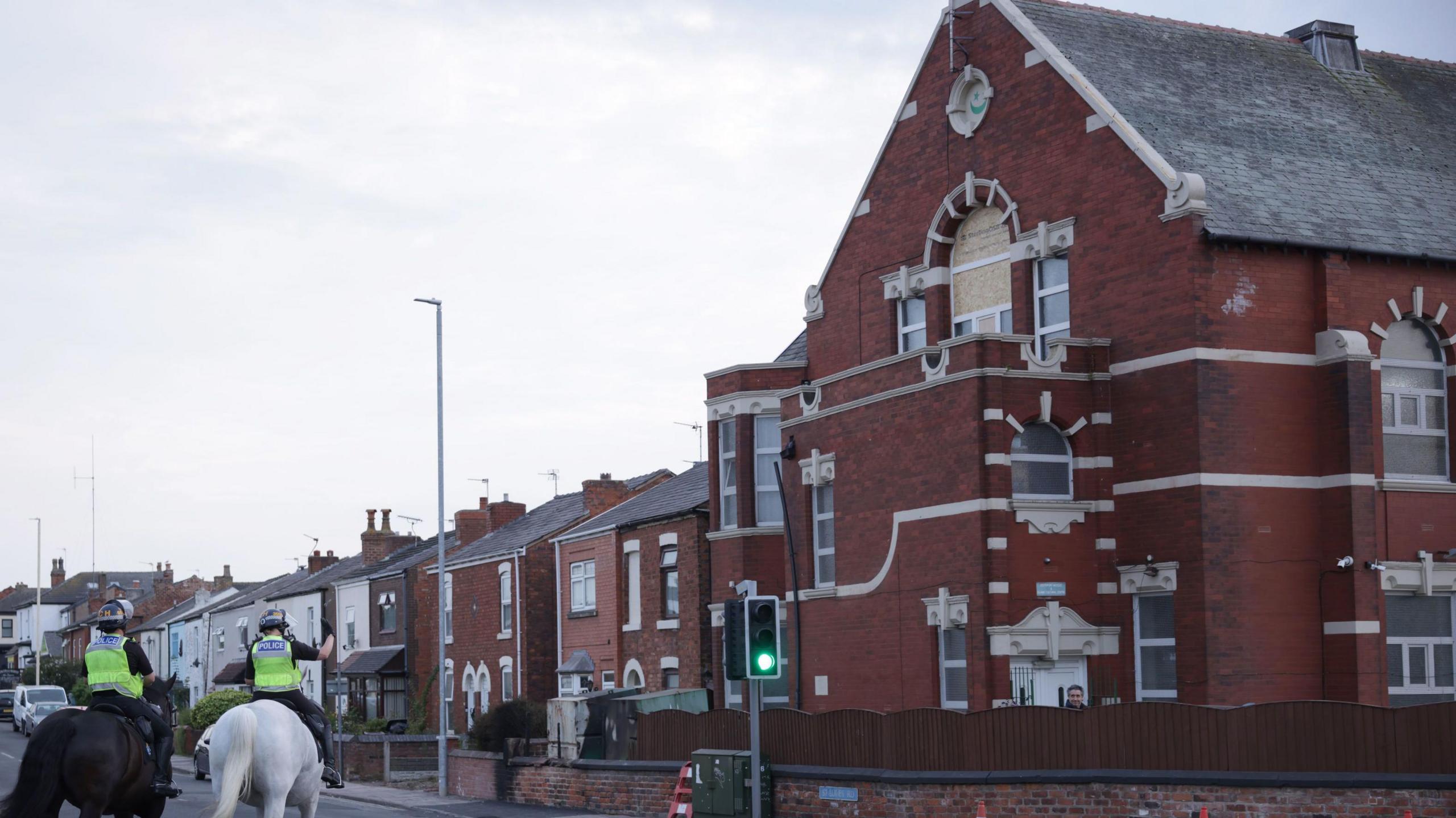 Mounted police officers patrol outside Southport Islamic Centre Mosque in Southport after violent disorder