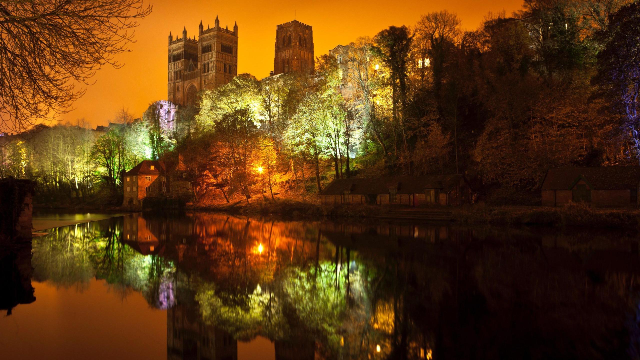 Wonderwood is a projection illuminating the trees below Durham Castle and Durham Cathedral in green, yellow and purple. The river reflects the shining trees and the buildings towering above them.