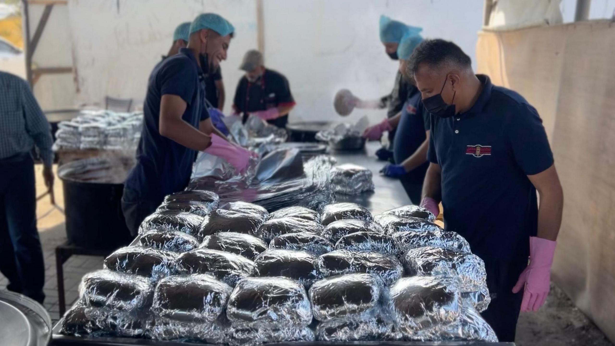 Anera communal kitchen staff make up parcels of koshari to distribute to Palestinians in al-Mawasi, southern Gaza
