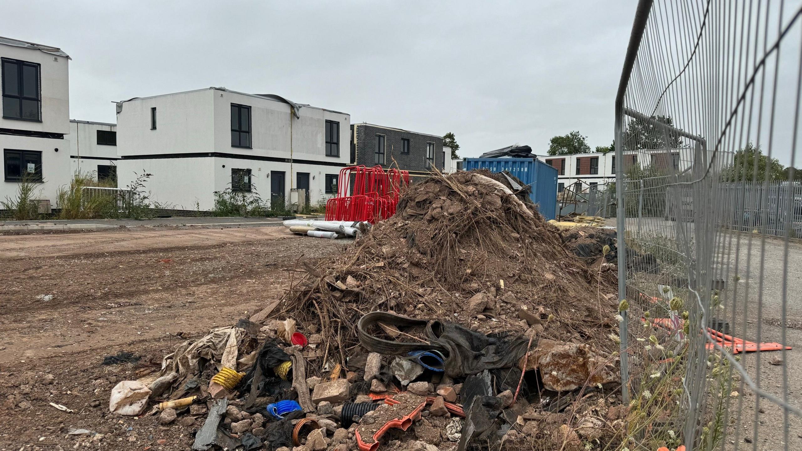 Piles of rubbish and unfinished homes on a building site