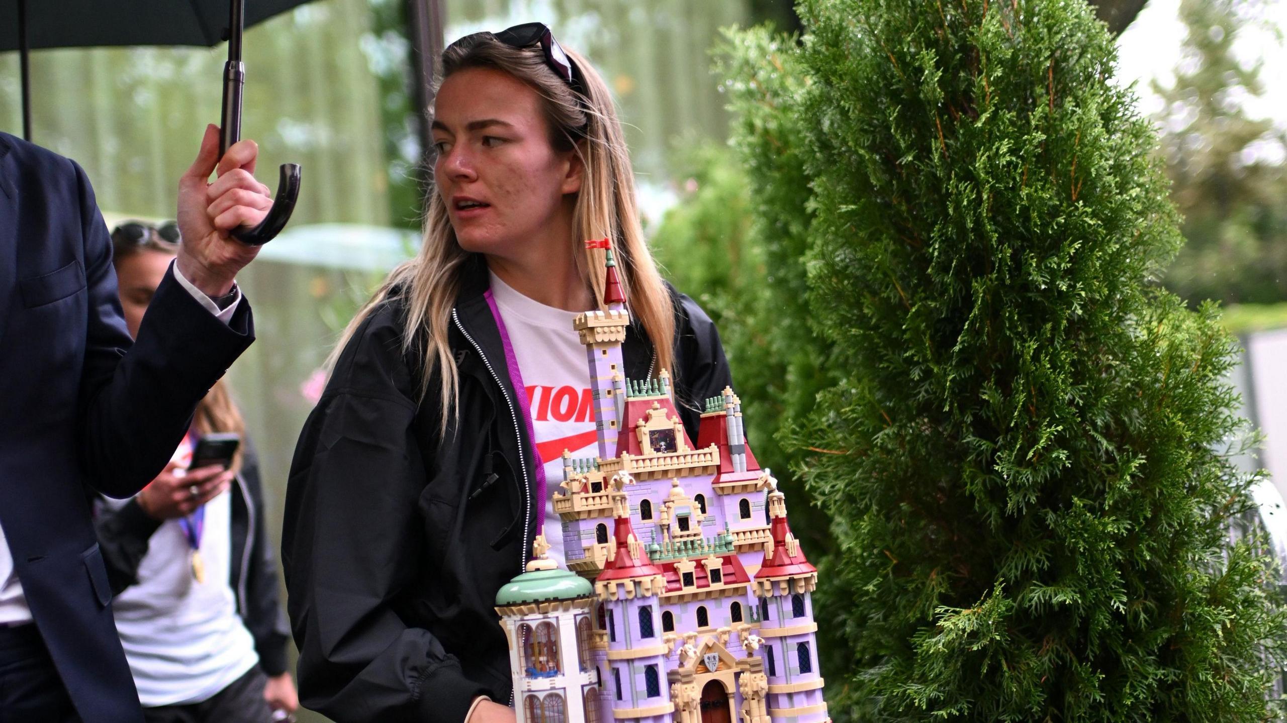 Lauren Hemp carries a Lego castle