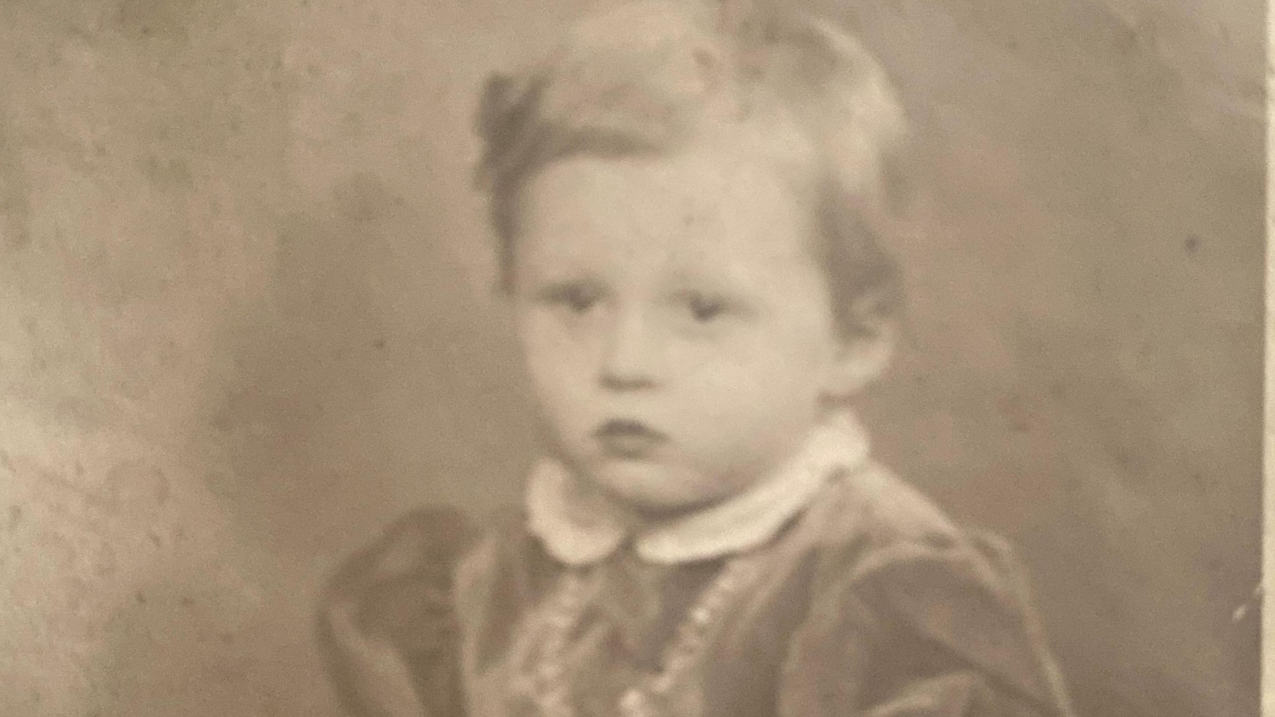 A grainy black and white image of Celia Henry taken when she was about 4 or 5. She is wearing a dress with a white collar 