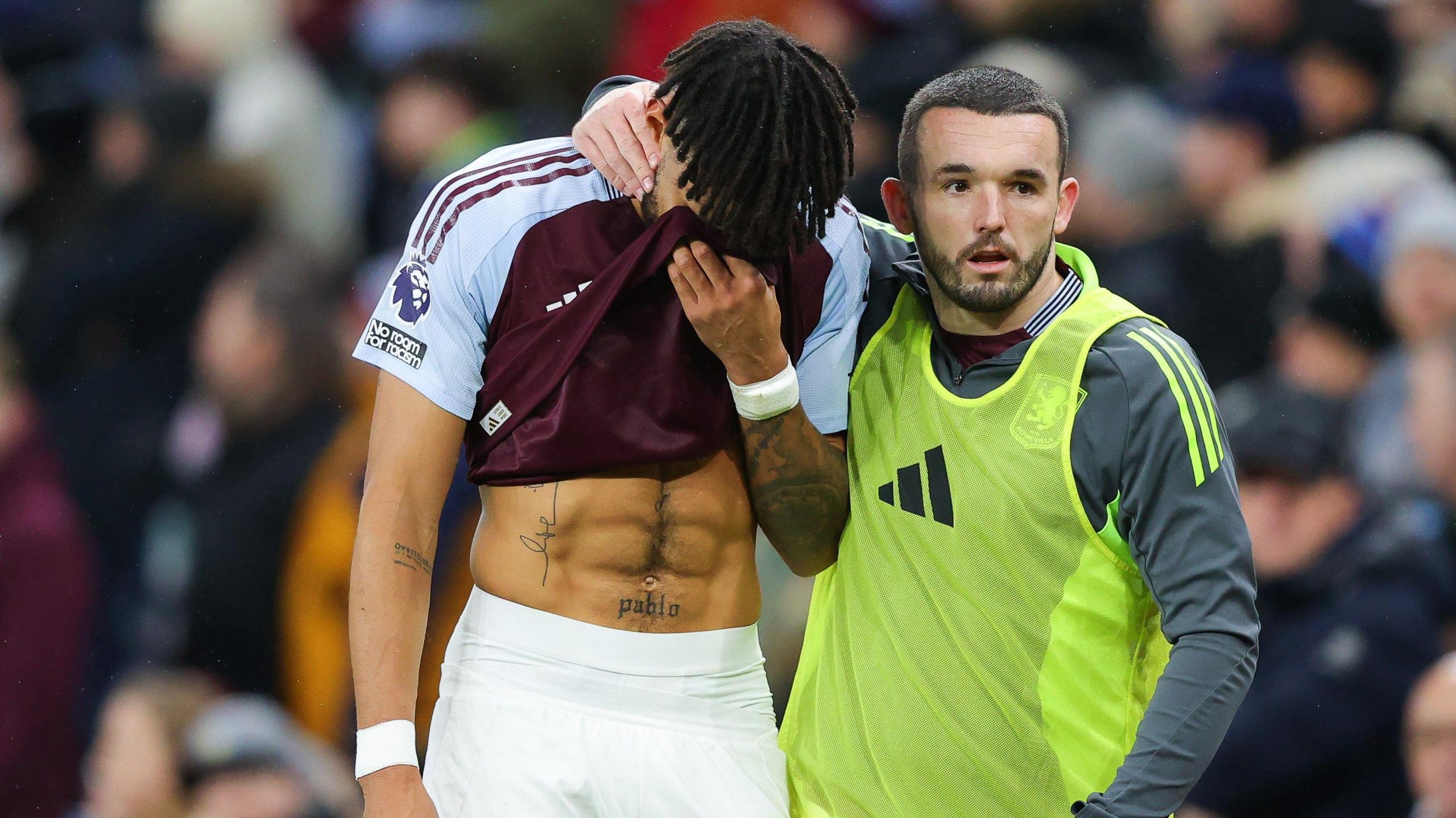 Tyrone Mings is comforted by John McGinn.