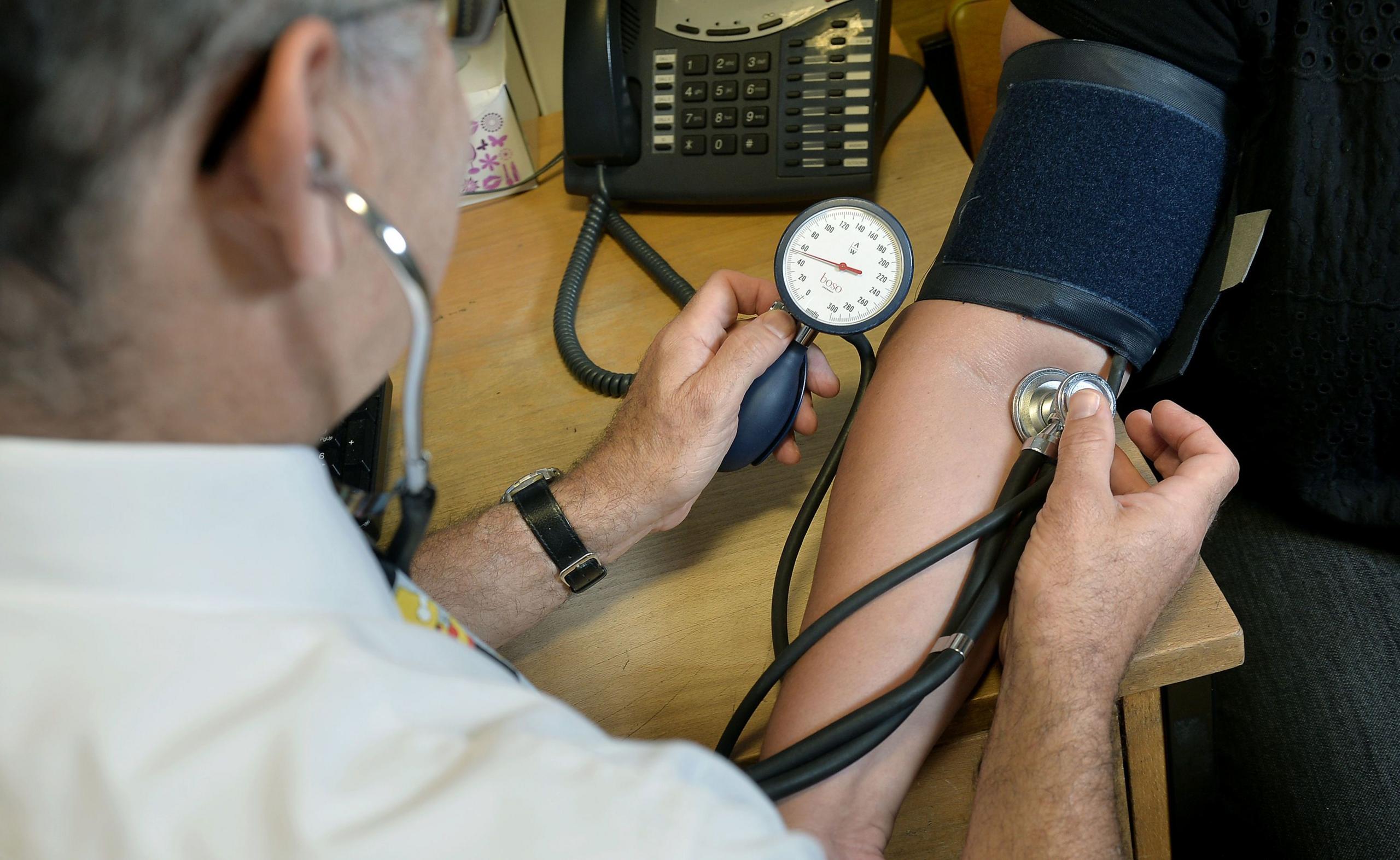 Doctor checking patient blood pressure