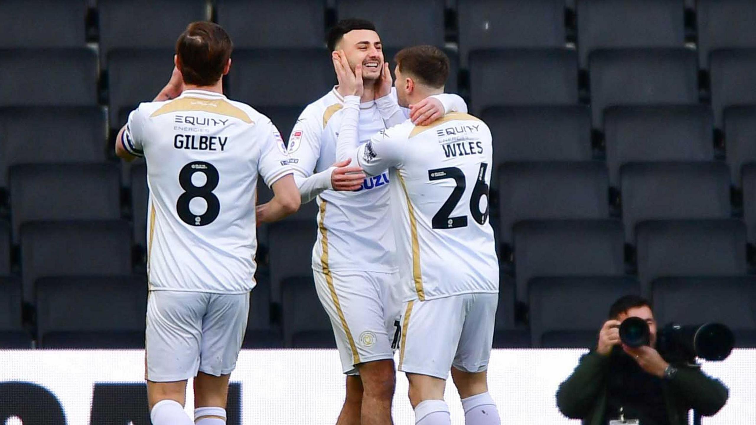 Aaron Collins of MK Dons (centre) celebrates