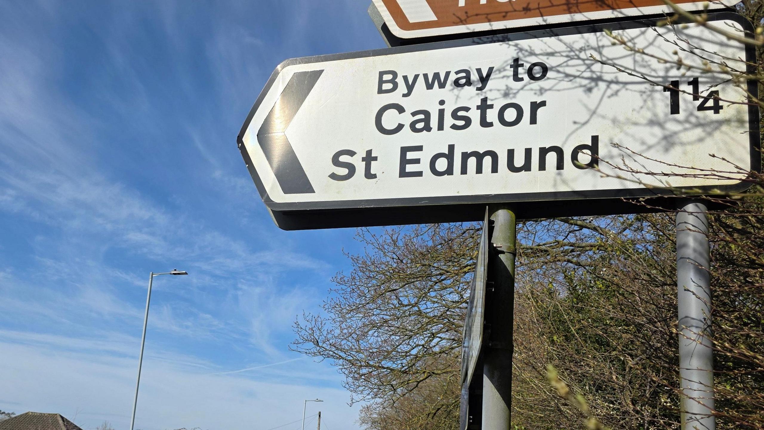 A road direction sign to Caistor St Edmund, which is one and a quarter miles away