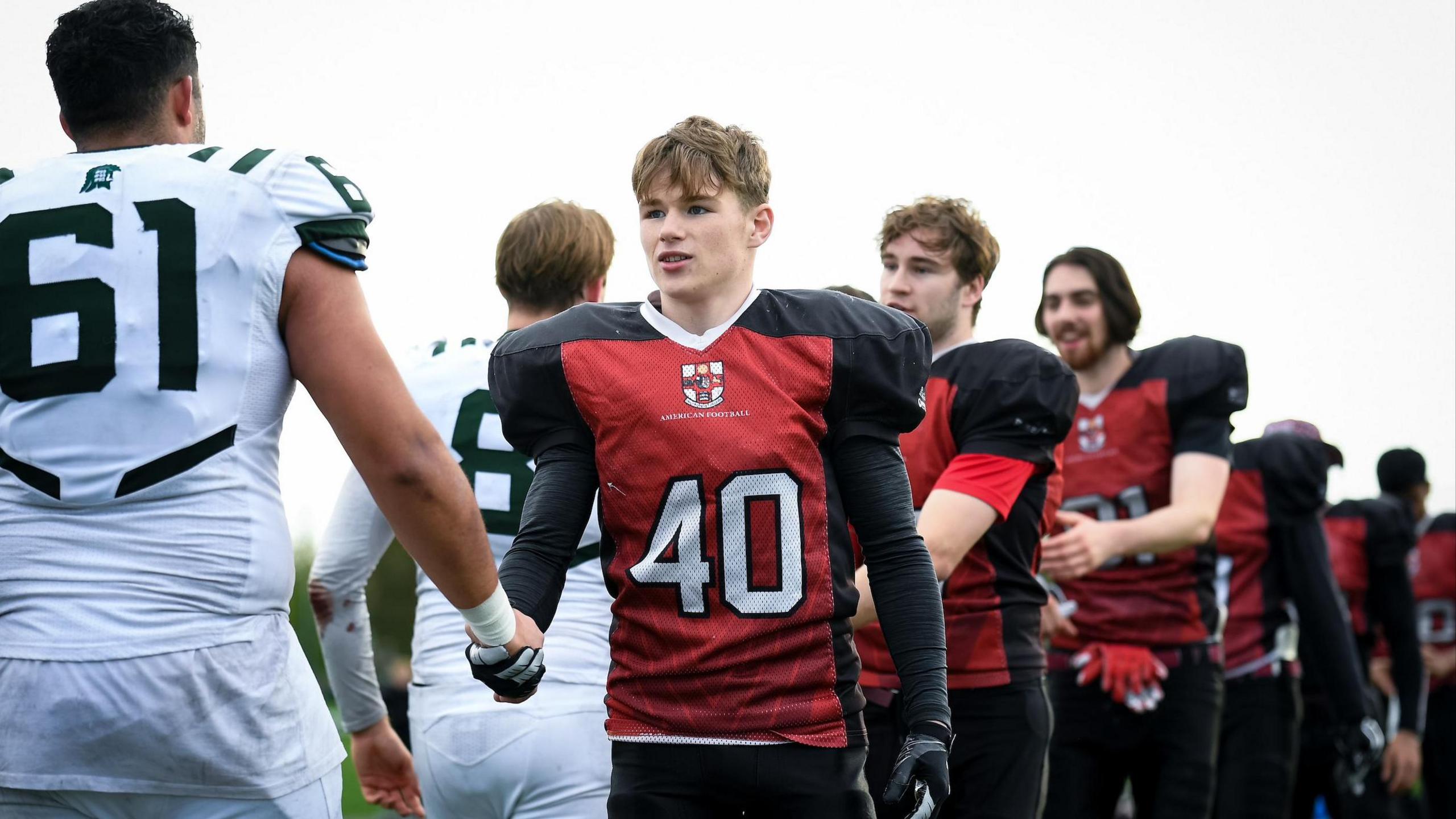 Archie in his black and red Bristol Barracudas kit shaking hands with the opposite team