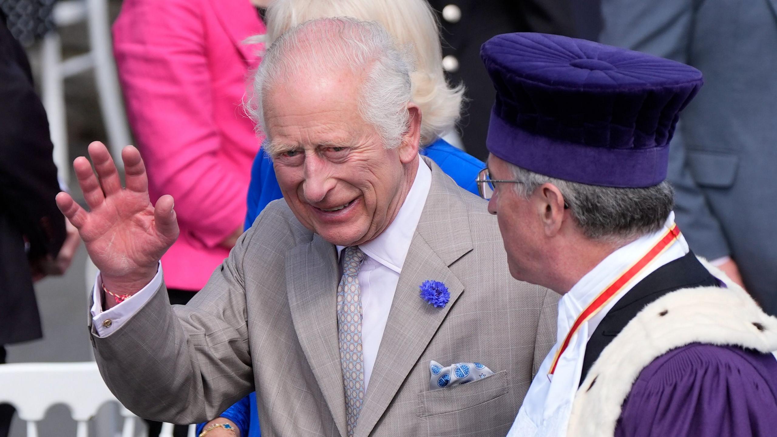 King Charles III waving to crowds in Guernsey accompanied by Bailiff Sir Richard McMahon