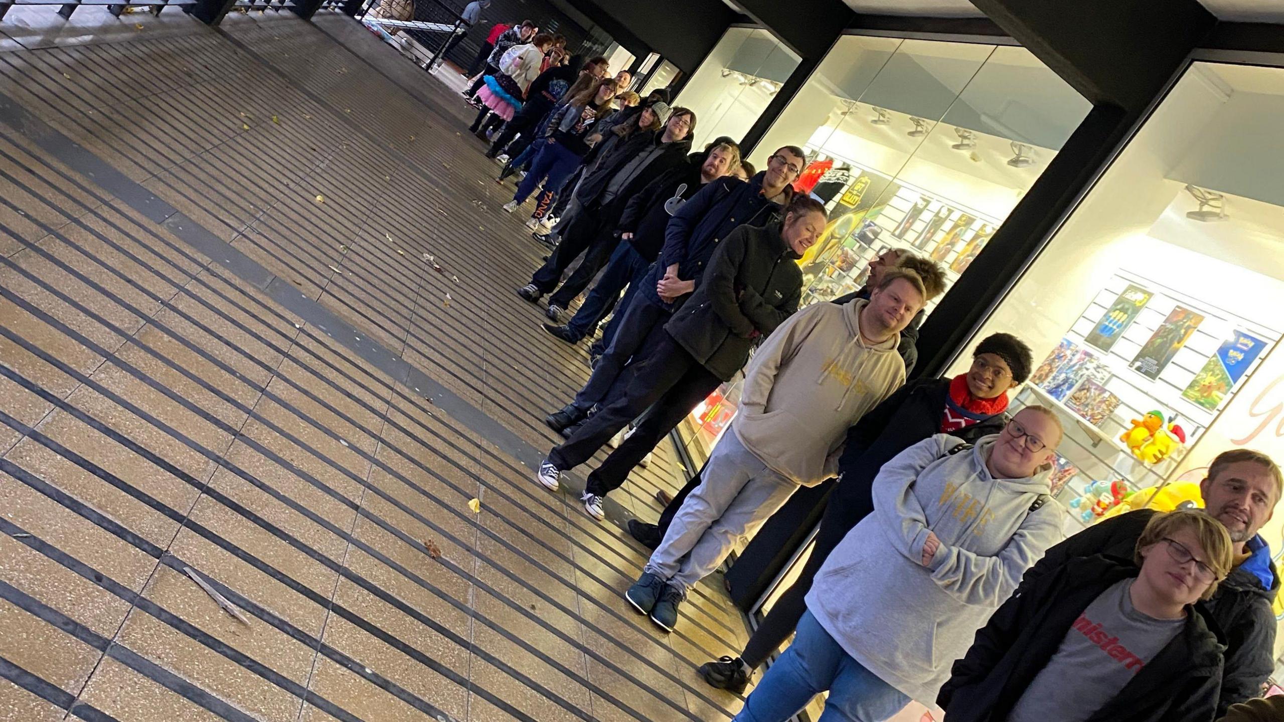 A group of people queuing outside the store