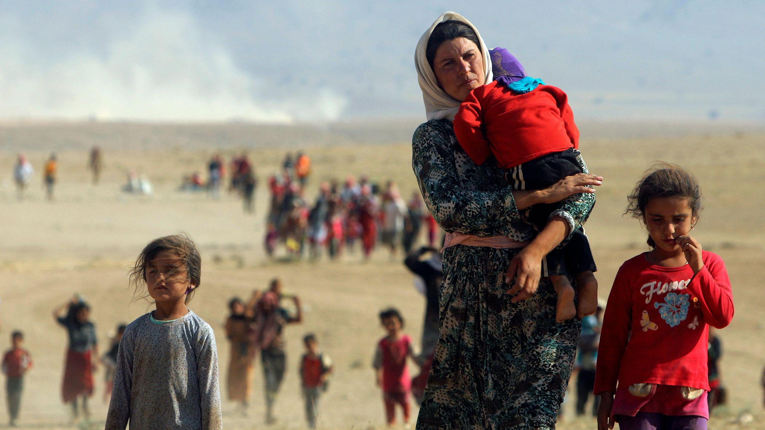 Woman with children fleeing Sinjar after IS attack in 2014