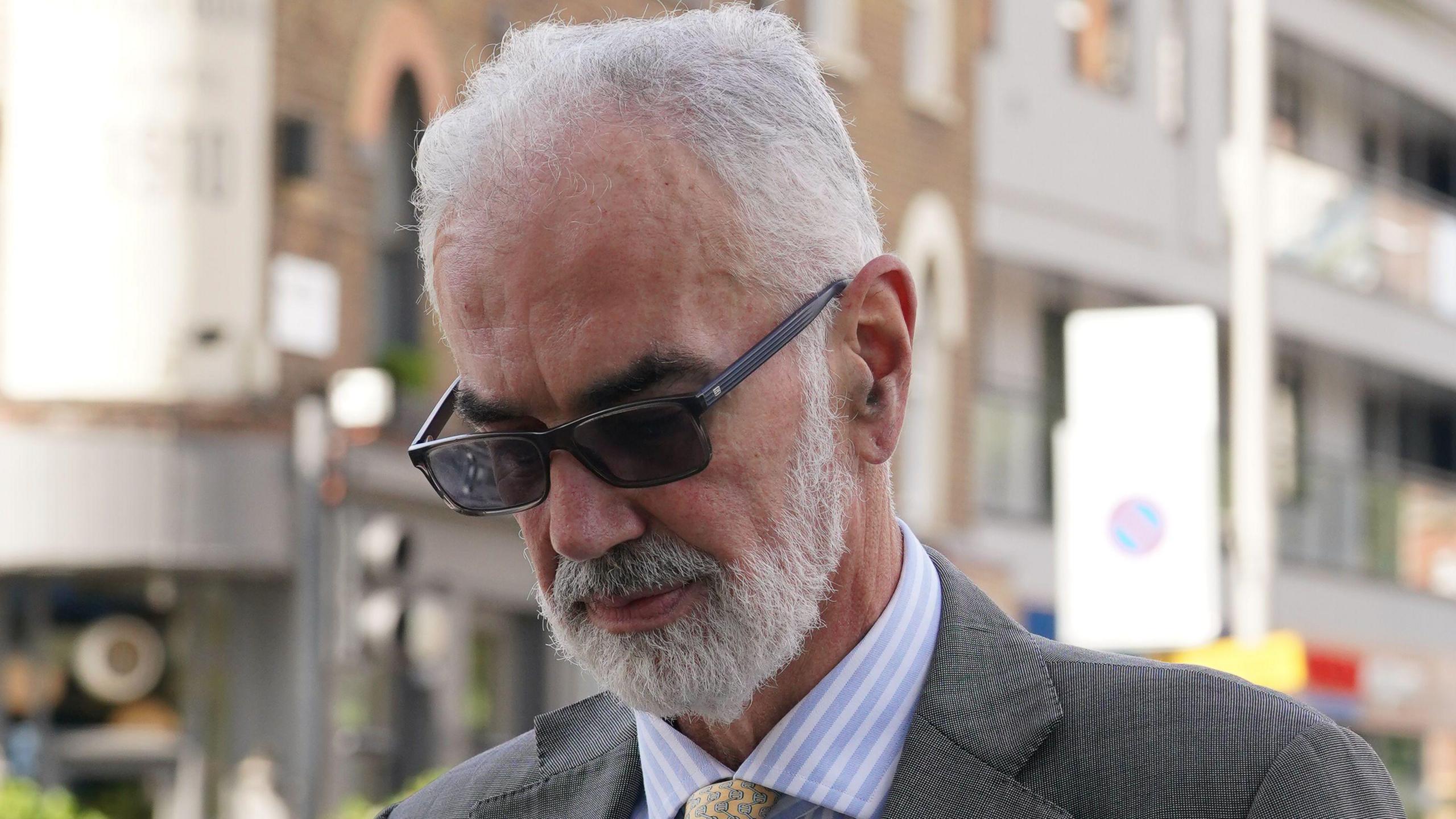 Sunglasses-wearing Commander Julian Bennett arrives at a Metropolitan Police misconduct hearing 