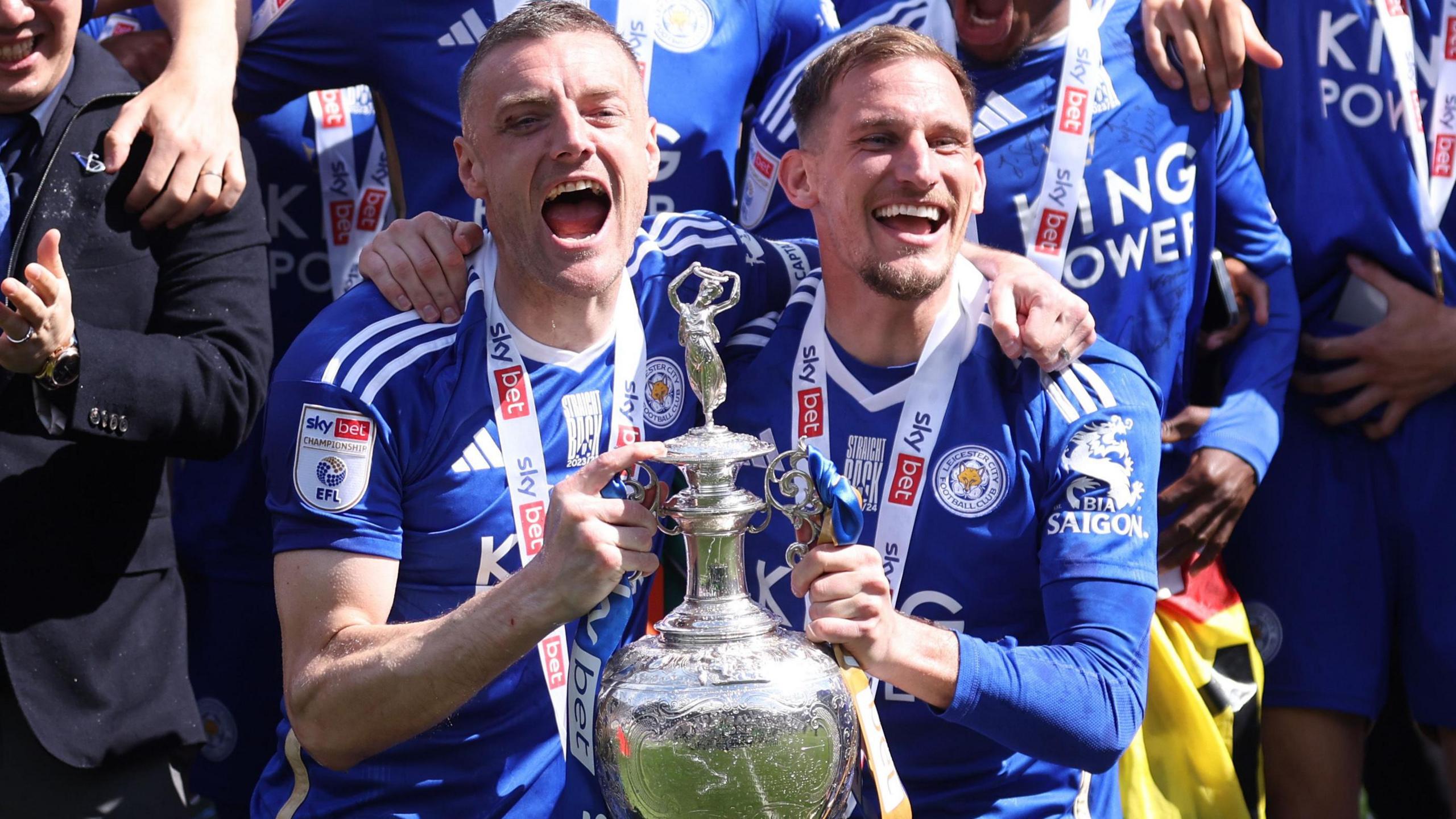 Jamie Vardy on the left and Marc Albrighton on the right hold the Championship trophy