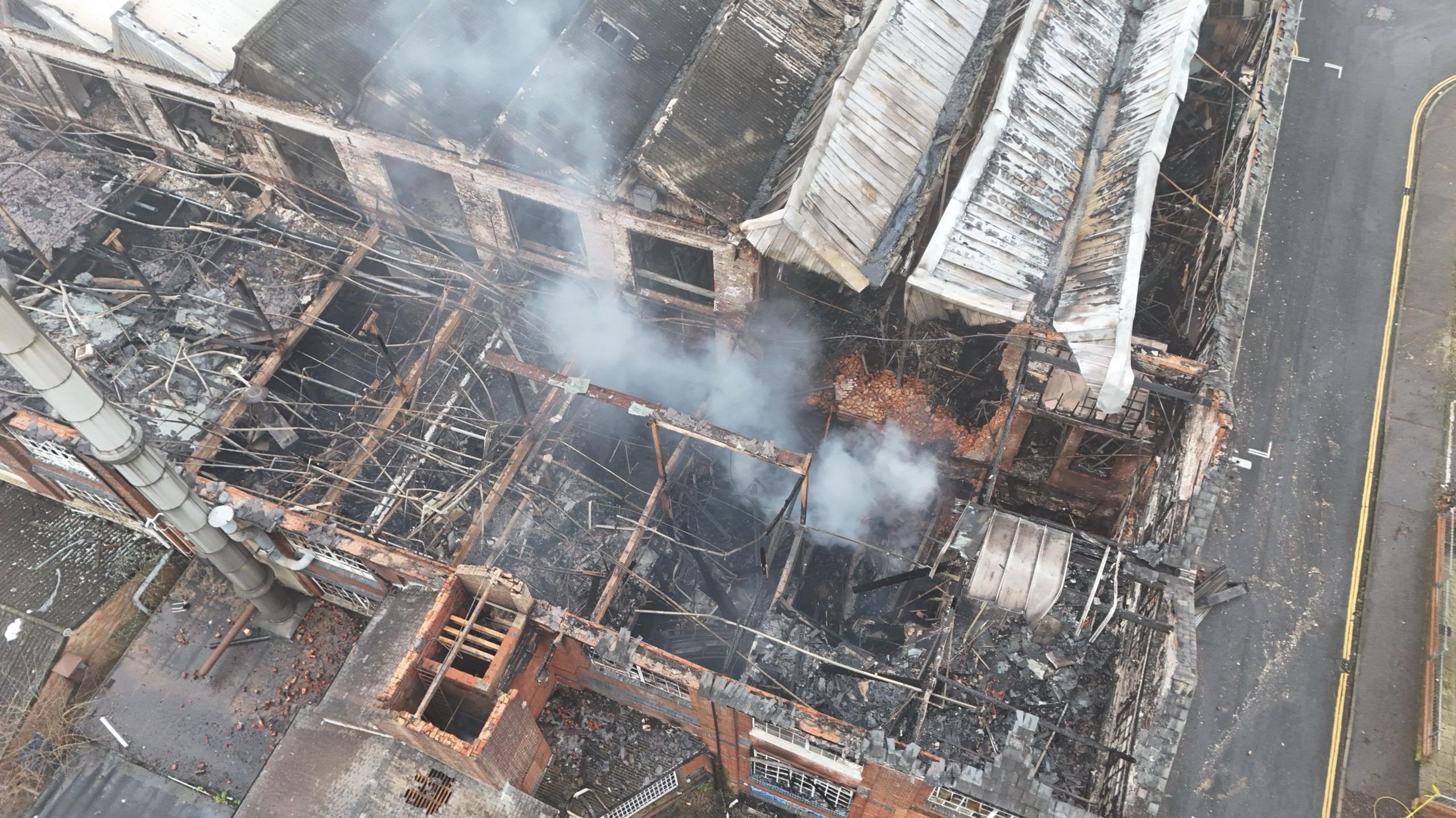 Smoke coming off of a derelict building which has been damaged from a fire. The picture has been taken above by a drone.