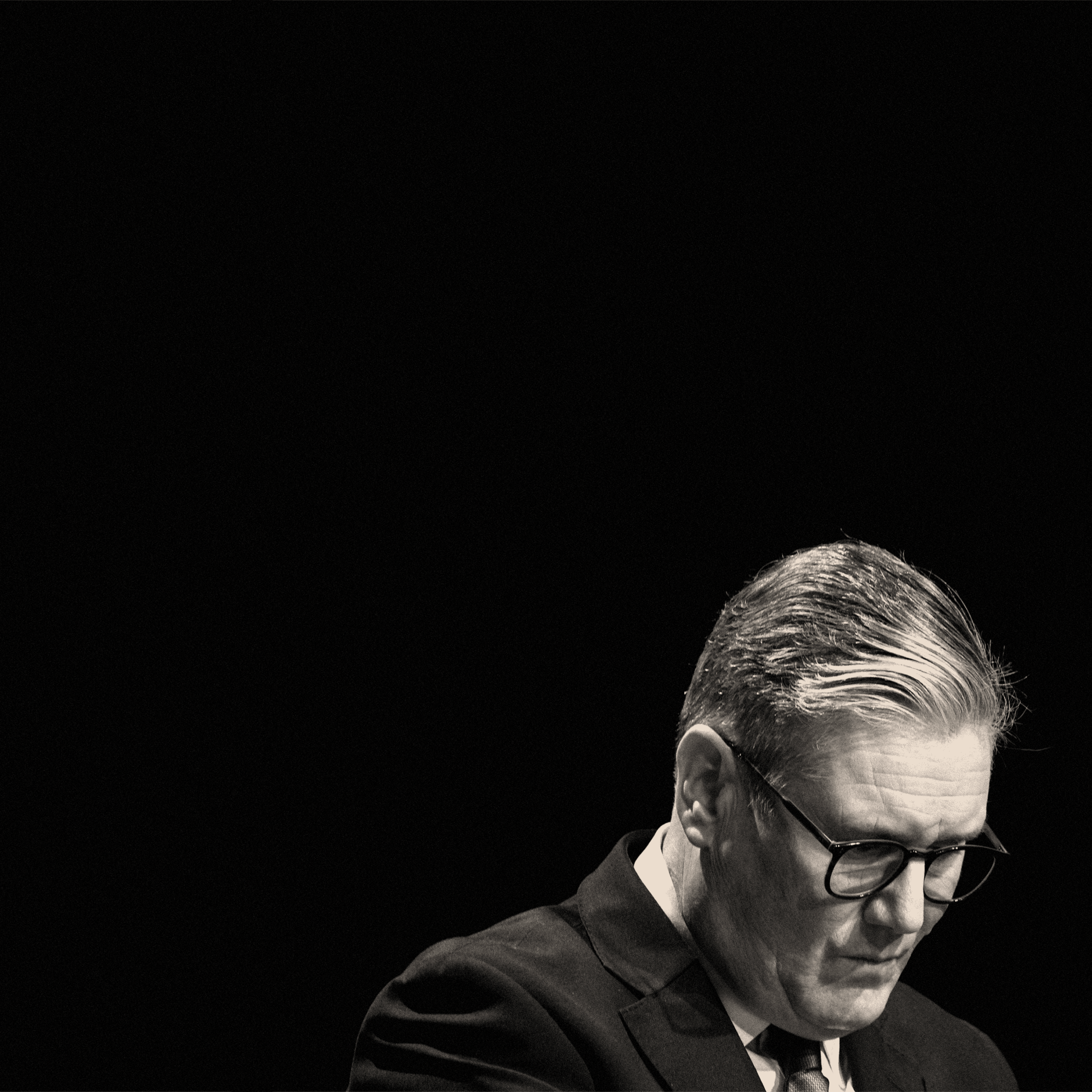 Starmer looking sad on a black background