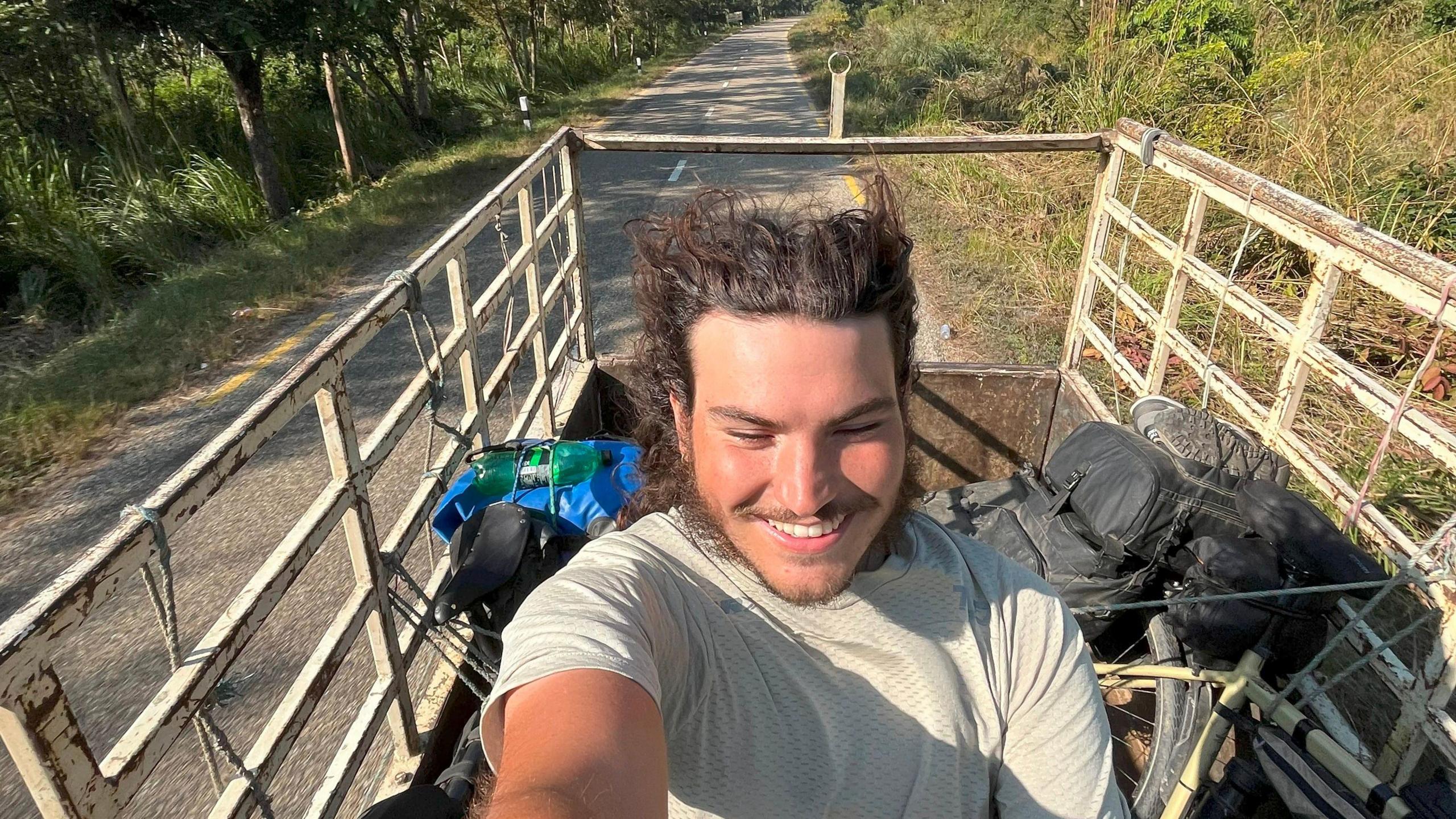 A man riding at the back of a lorry escaping a tiger that was attempting to attack motorcyclists in Nepal.