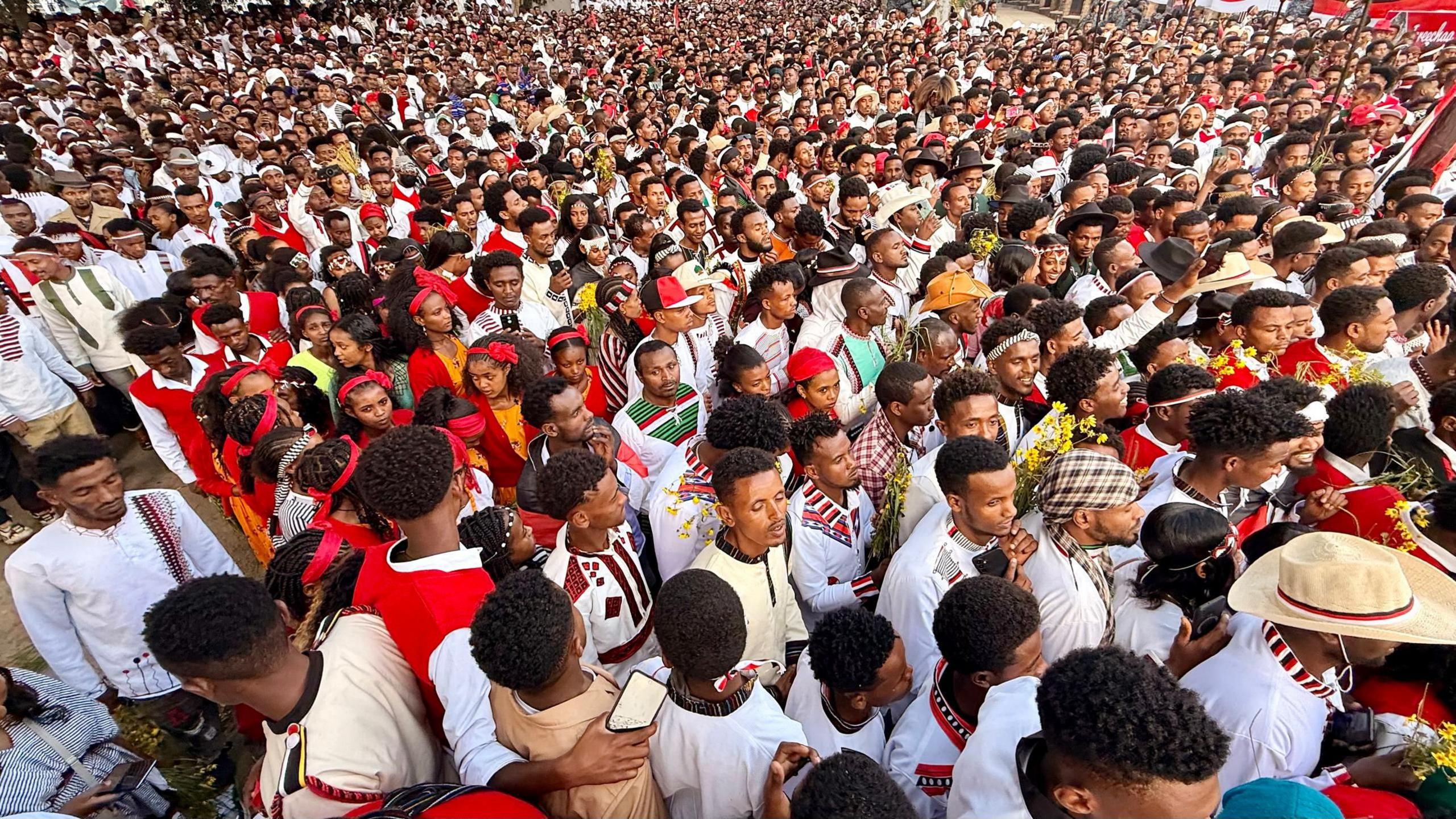 A huge crowed of people, mostly wearing white, is pictured from above
