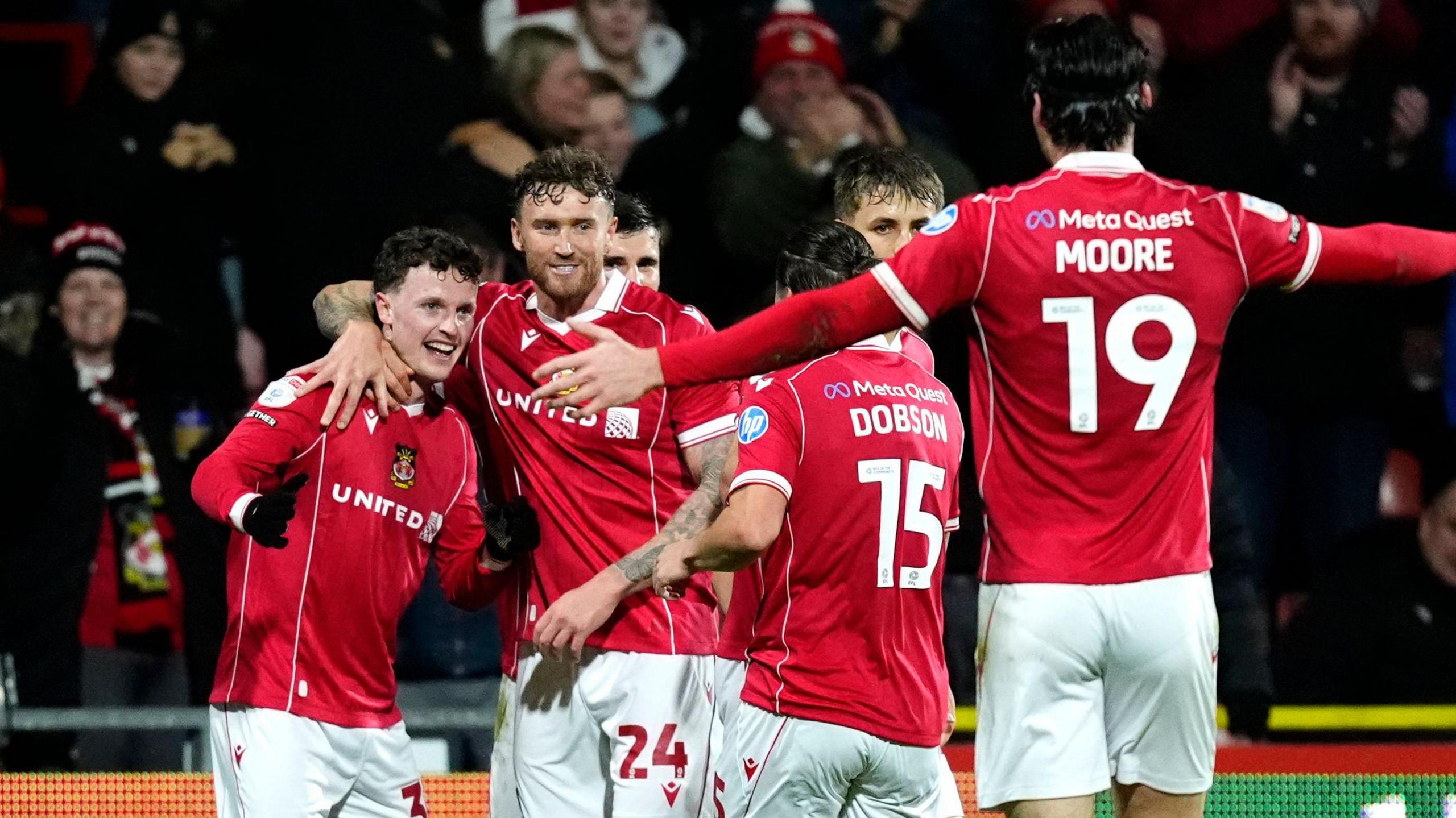 Wrexham forward Nathan Broadhead (L) celebrates with (L to R) Dan Scarr, George Dobson and Kieffer Moore