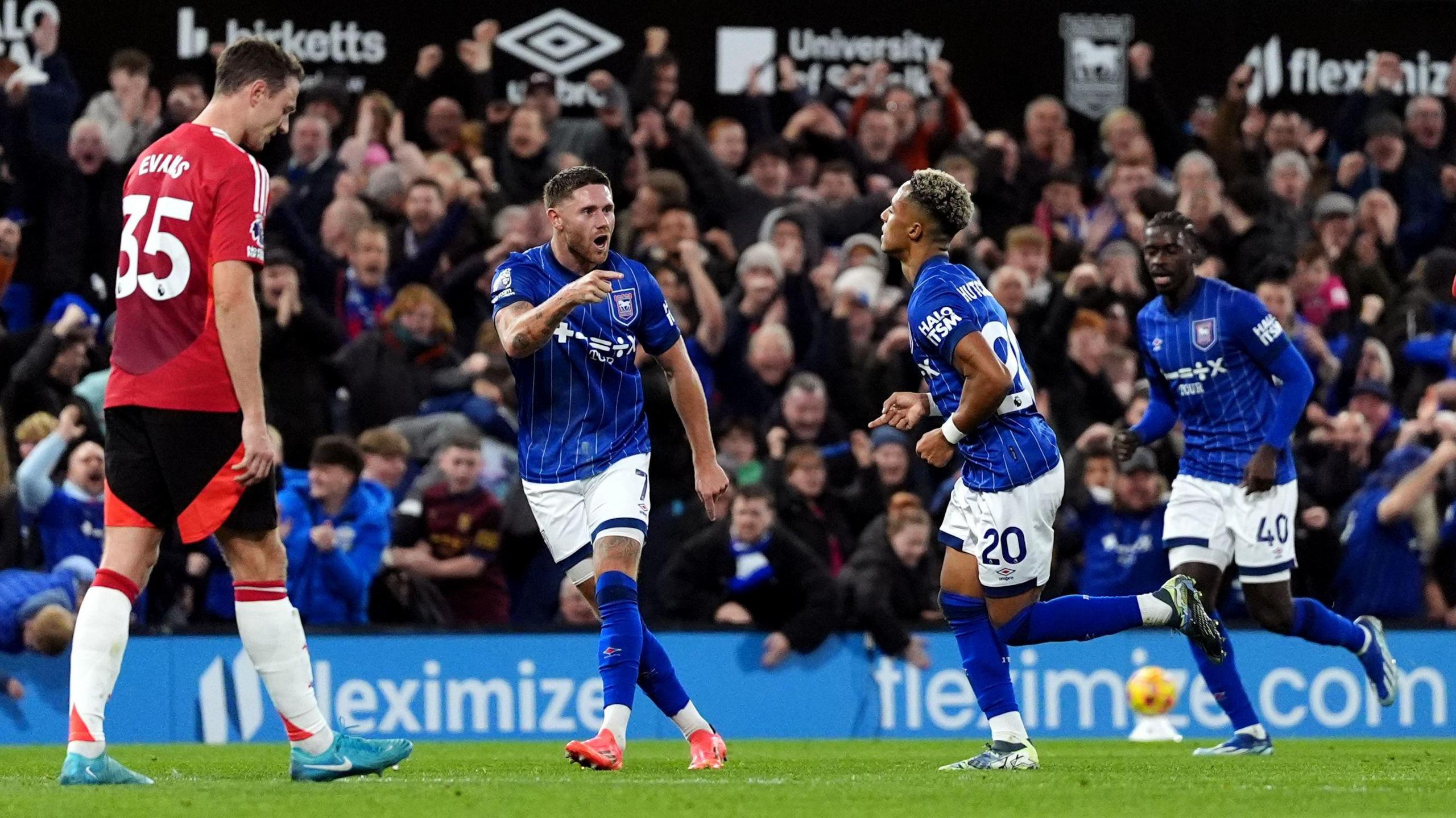 Ipswich Town players Wes Burns and Axel Tuanzebe run to congratulate Omari Hutchinson after he scored an equaliser to make it 1-1 in the game with Manchester United at Portman Road. Manchester United defender Jonny Evans is also in the picture looking dejected while fans celebrate in the background