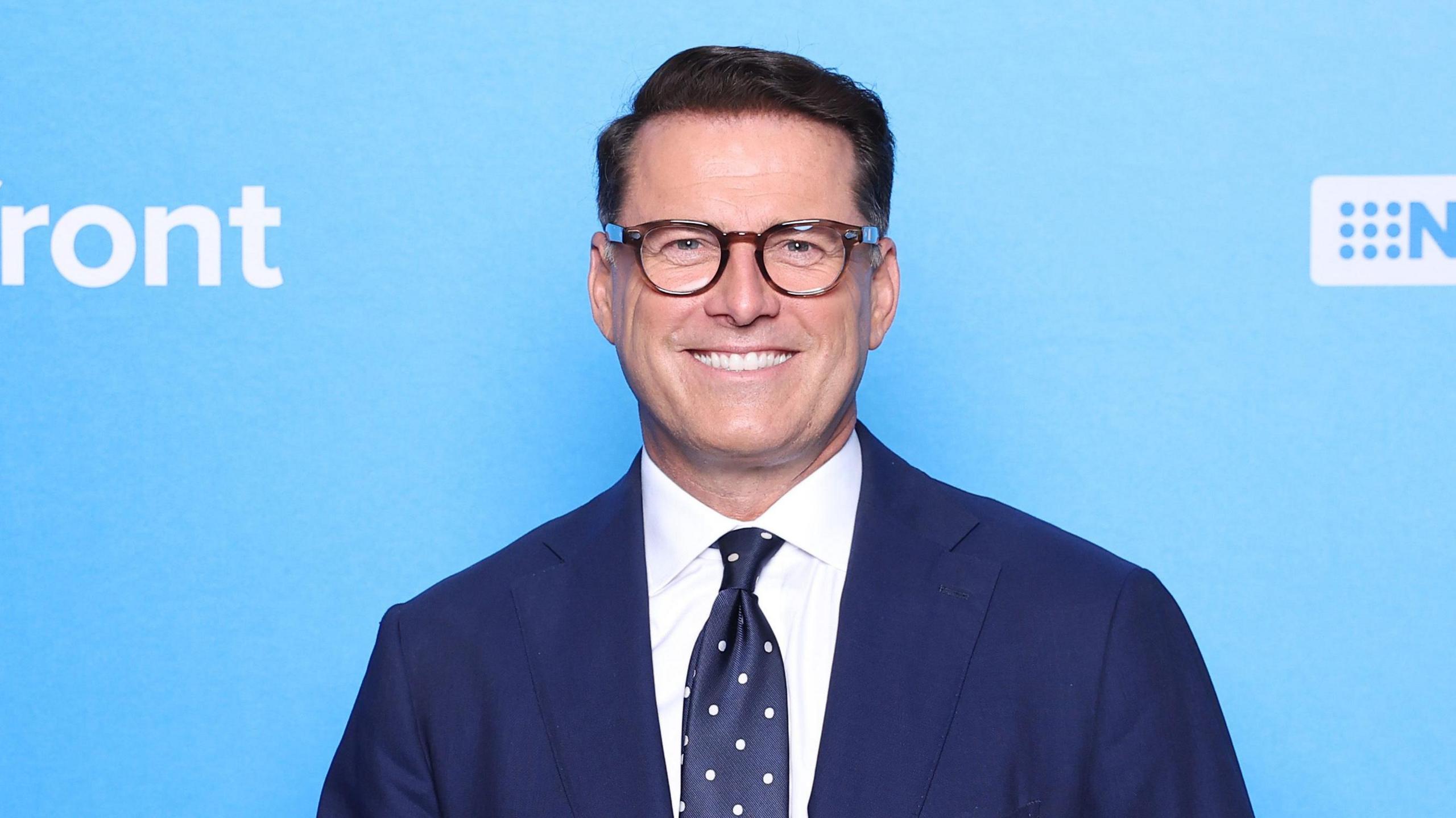 Karl Stefanovic poses in front of a blue wall