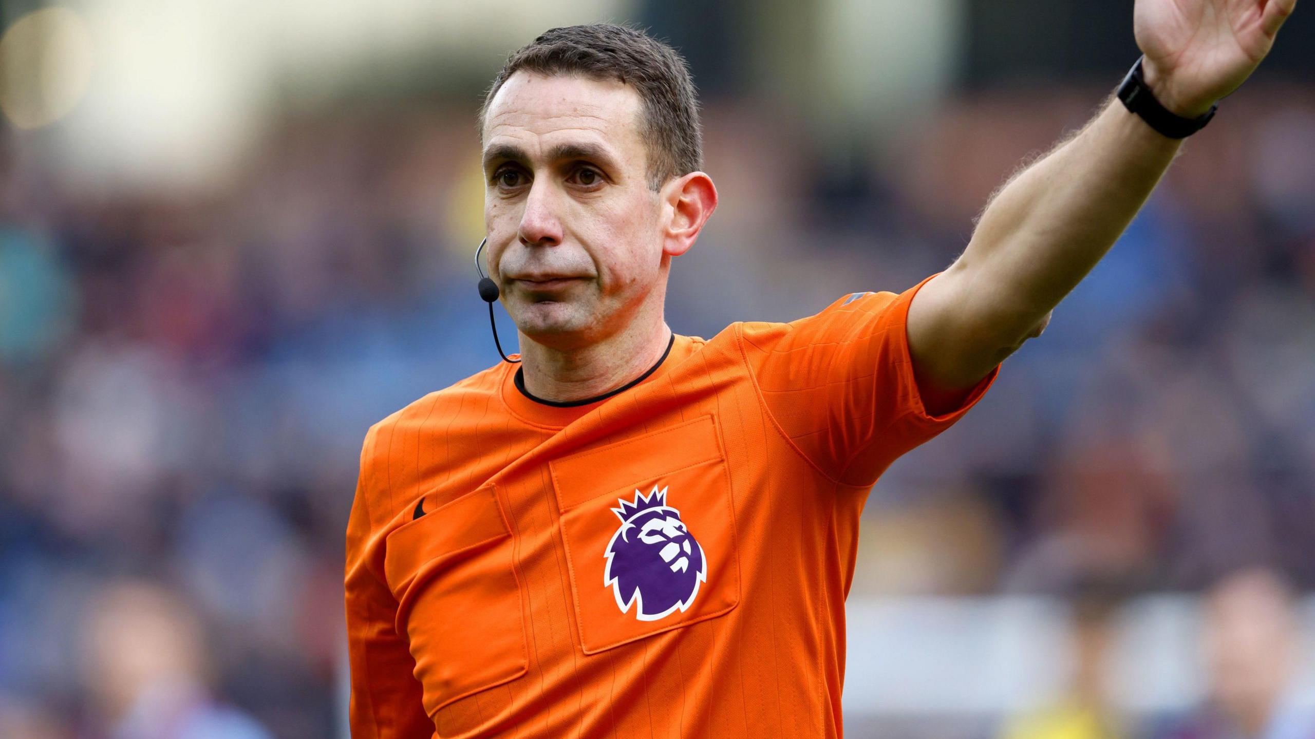 Referee at football match with hand in the air