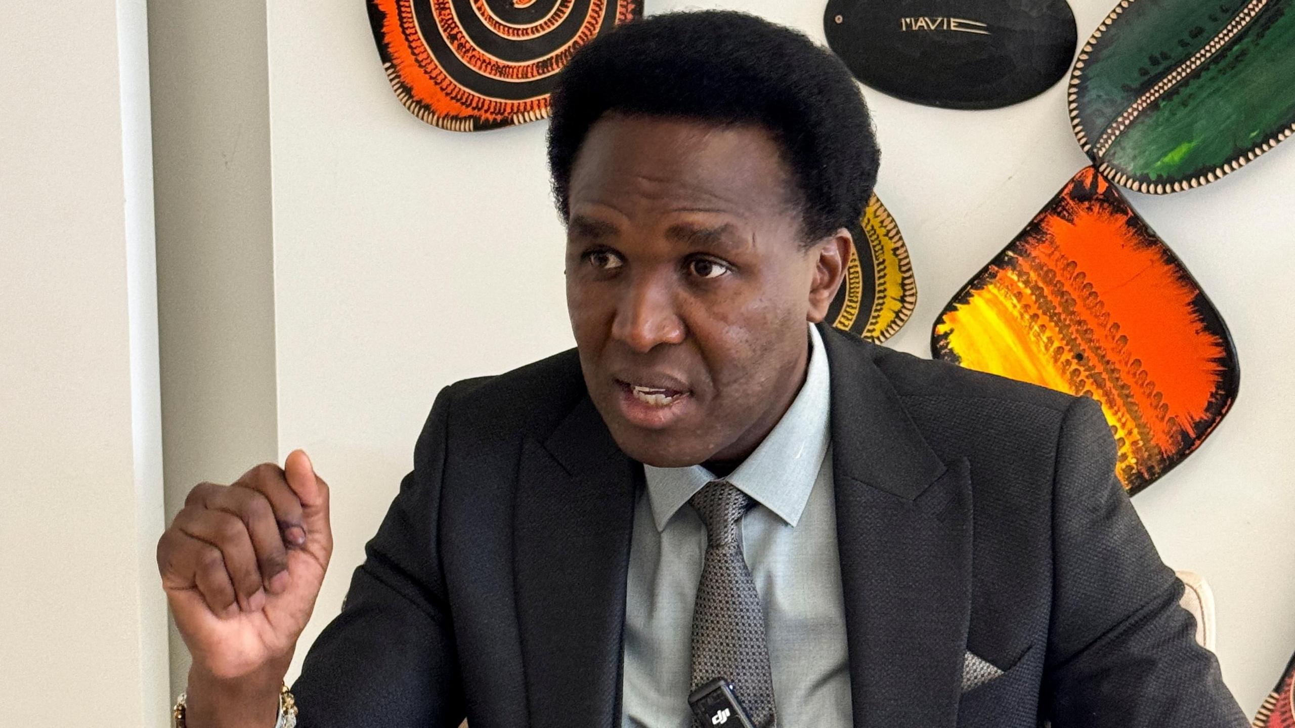 Venancio Mondlane in a dark suit and grey ties speaks during an interview in Maputo, Mozambique