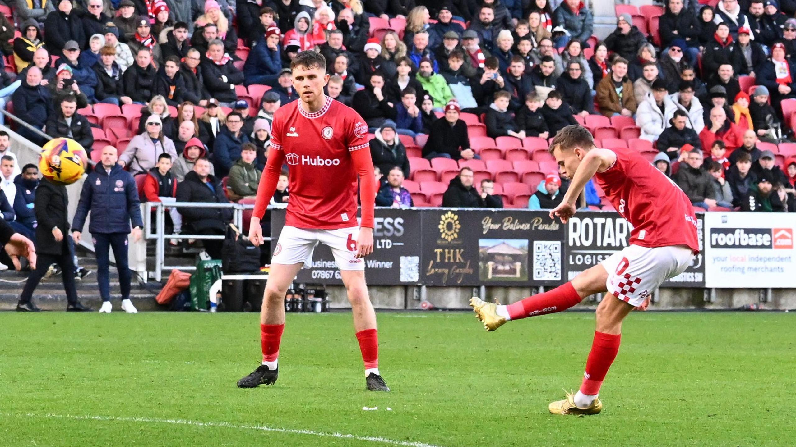 Scott Twine (right) takes a free-kick