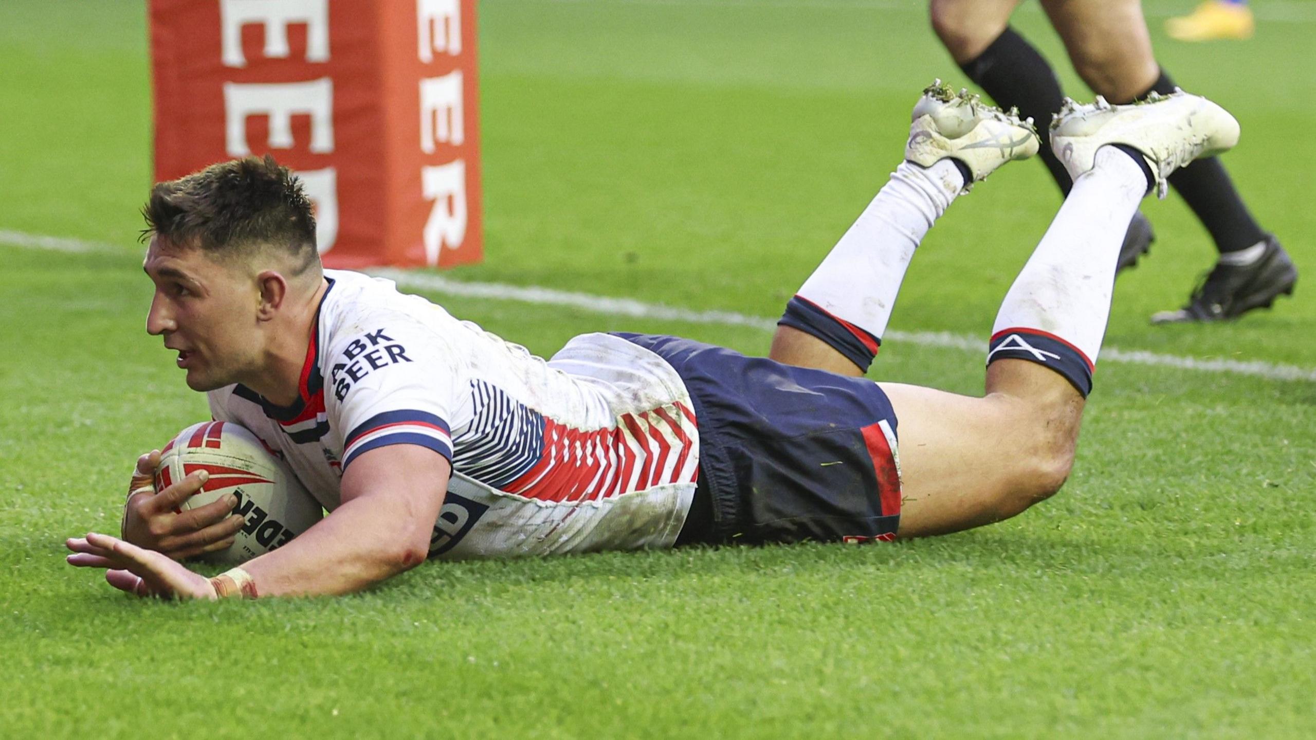 Victor Radley on the ground with the ball in his hand under the posts