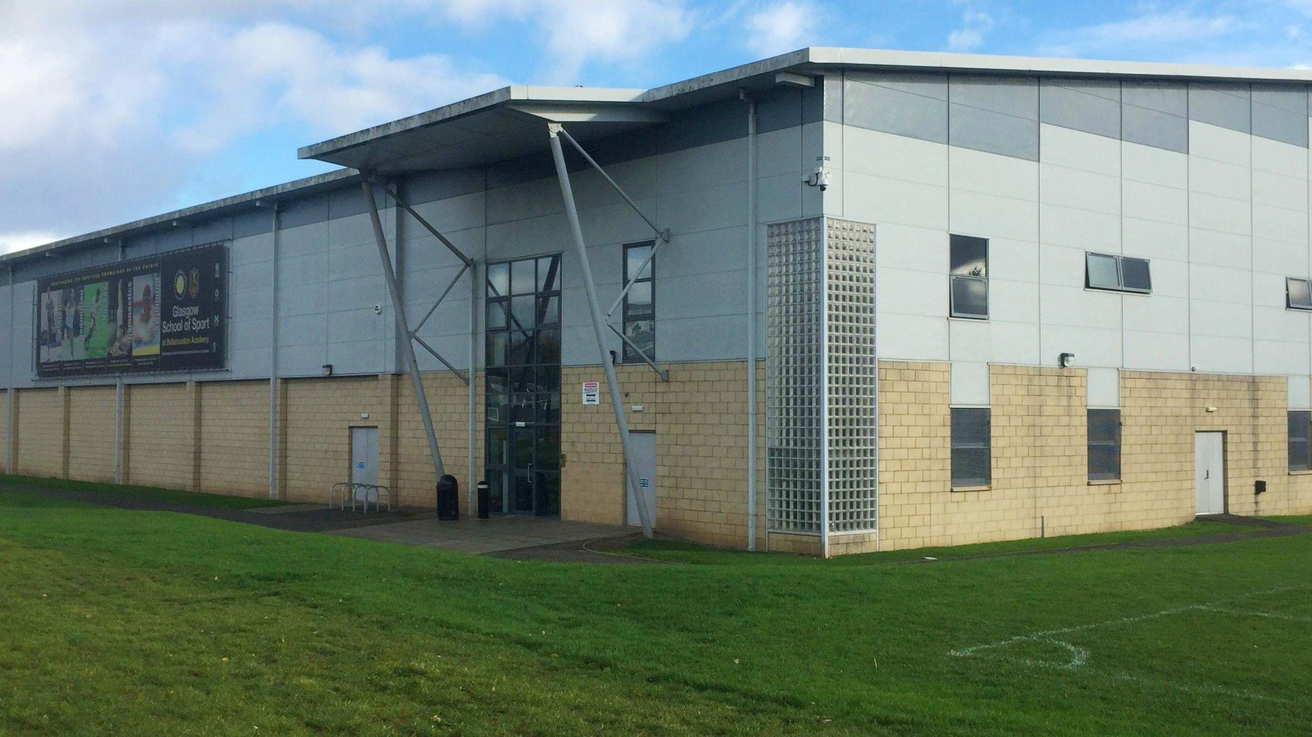 The Glasgow School of Sport building - playing fields are outside the building, which is a mix of sandstone bricks and grey/white.
