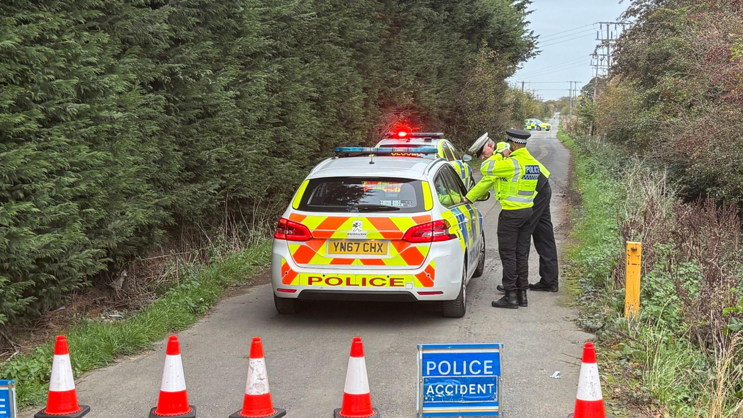 Some cones, a sign reading "police accident" sat in the road, and a police car