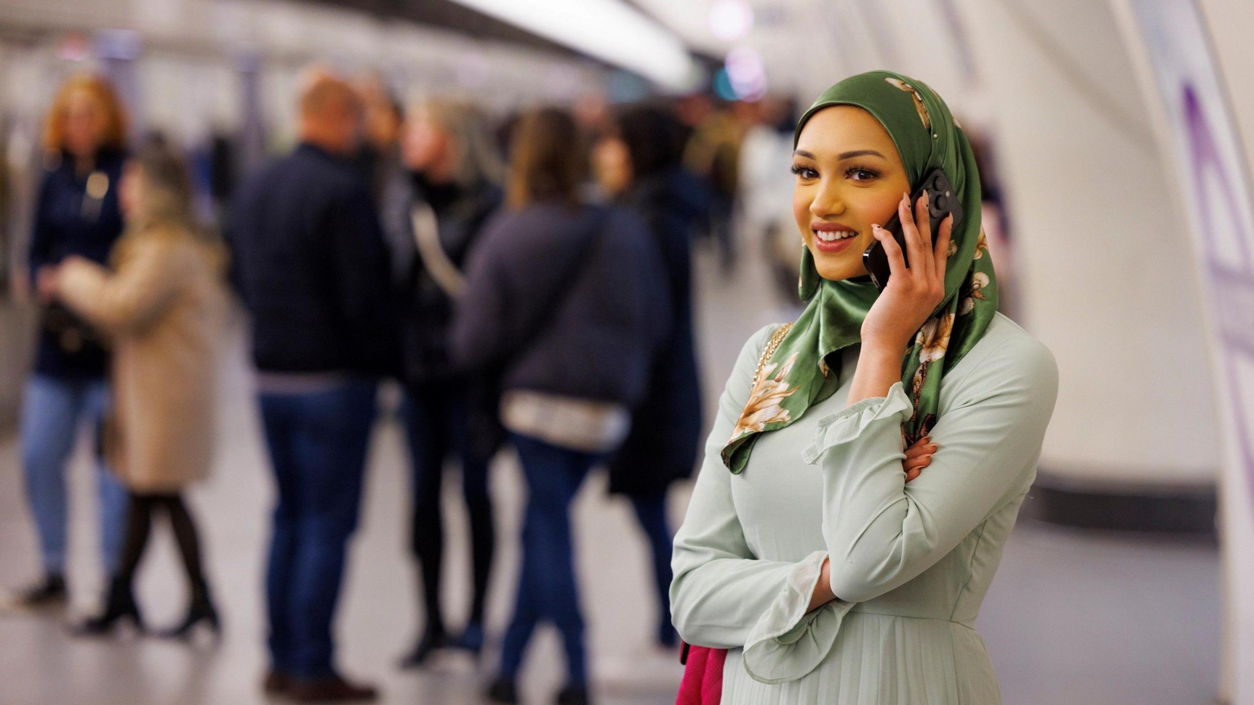 A woman on a phone in an Elizabeth line station