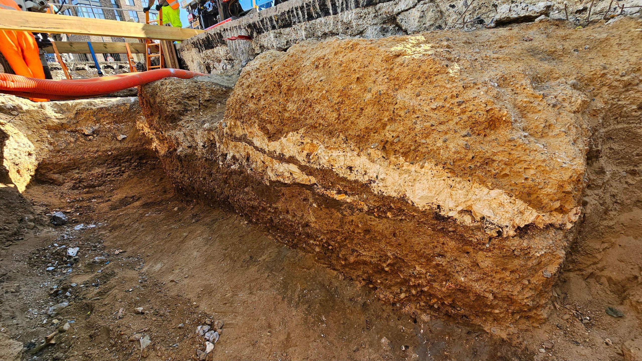 A photograph of the road showing several layers of the Roman road underneath the modern tarmac surface 