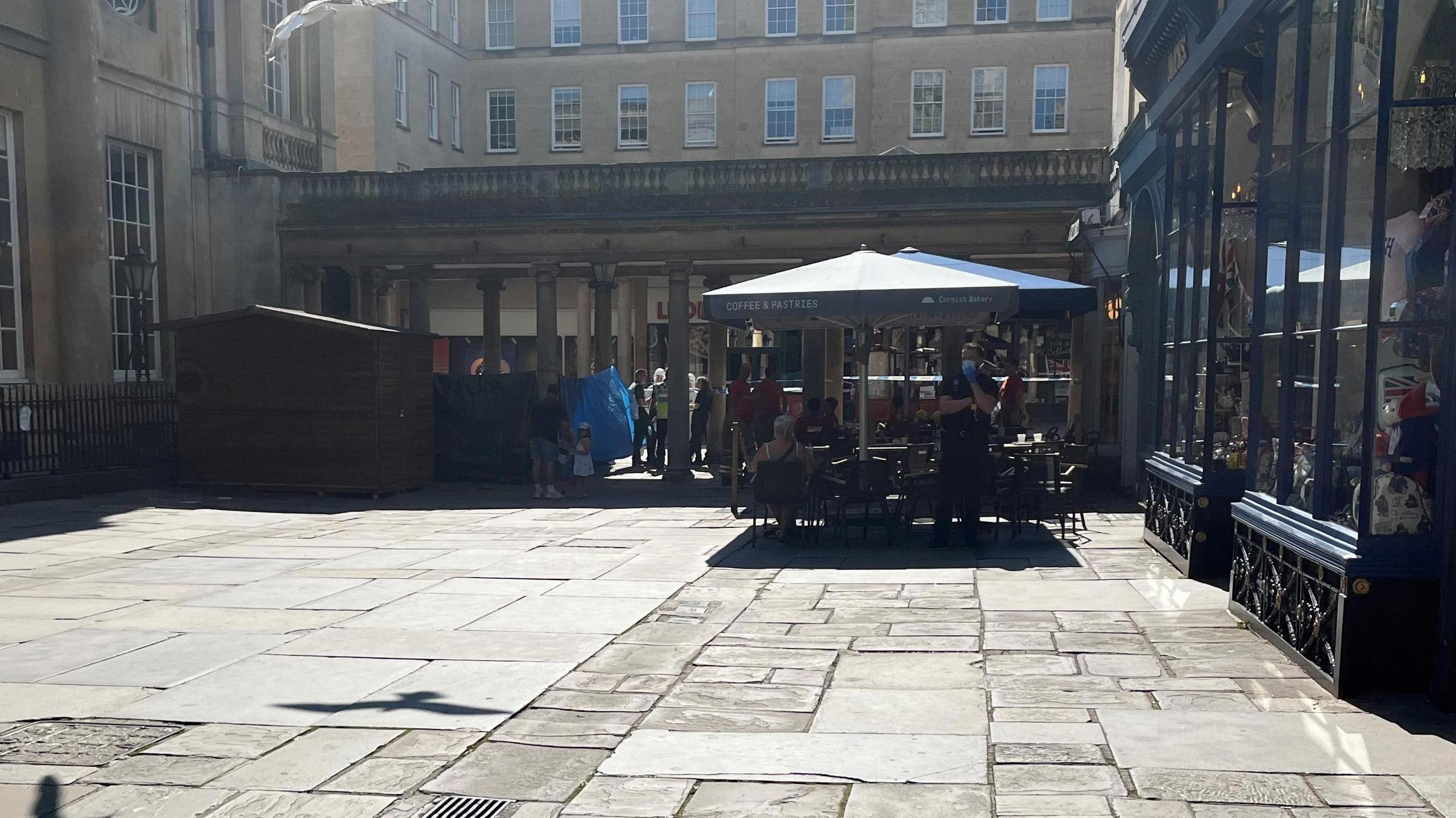 A blue tent can be seen within a police cordon