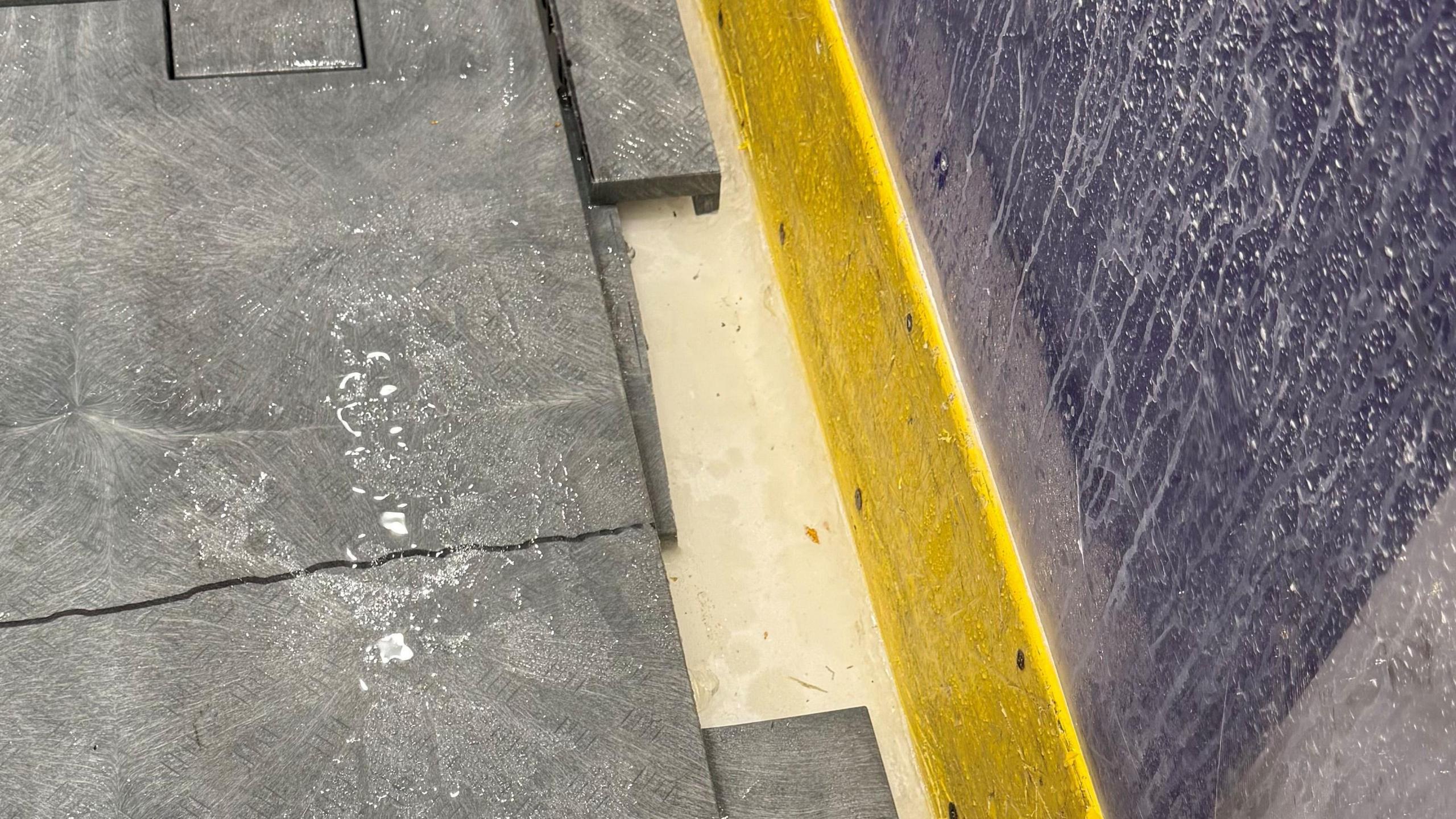 A floor with water all over it. A back wall has condescension running down it.  