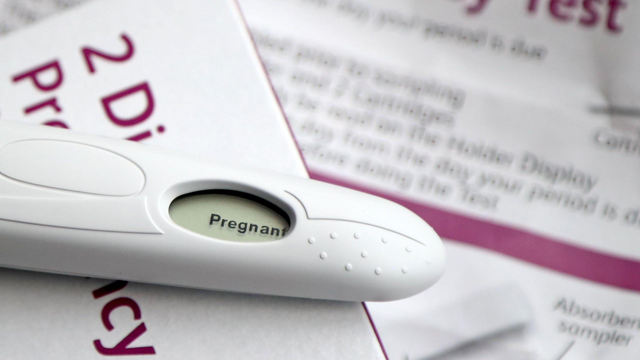 A pregnancy test has a small digital screen which says "positive"