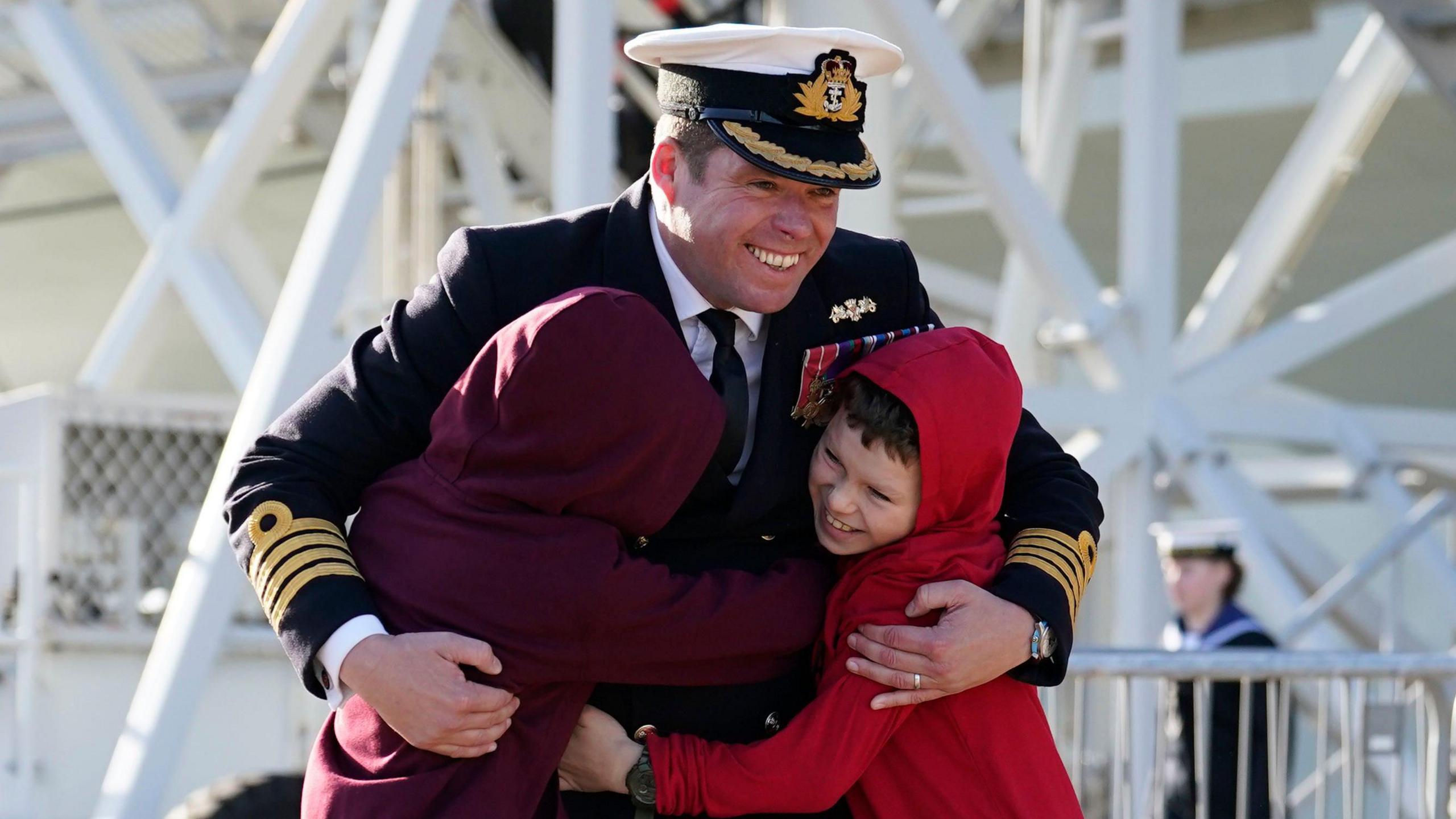 Captain Richard Hewitt, commanding officer of HMS Prince of Wales, is greeted by his sons Oliver and William