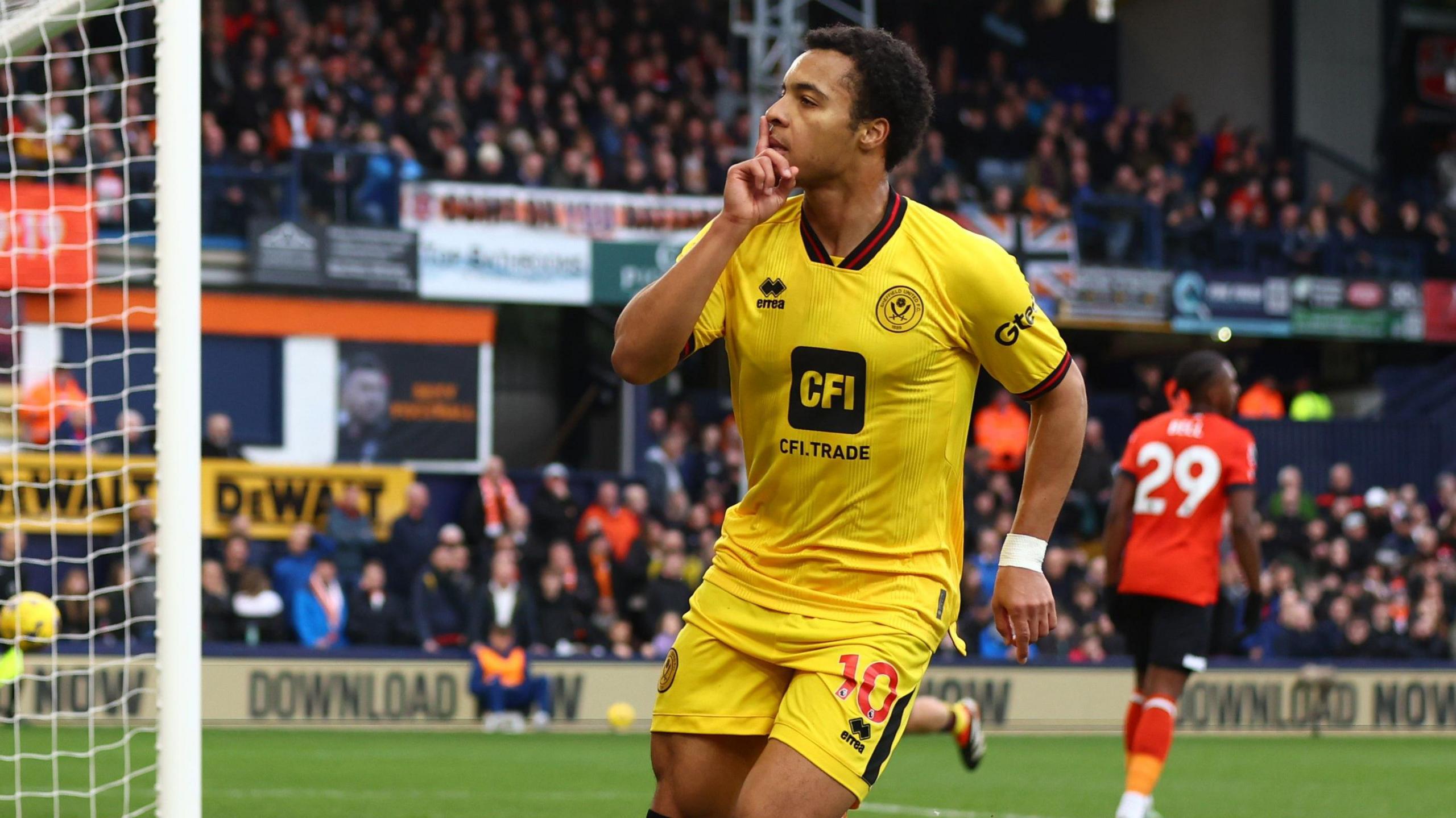 Cameron Archer, wearing Sheffield United's yellow away strip, puts his finger to his lips in celebration after scoring at Luton.