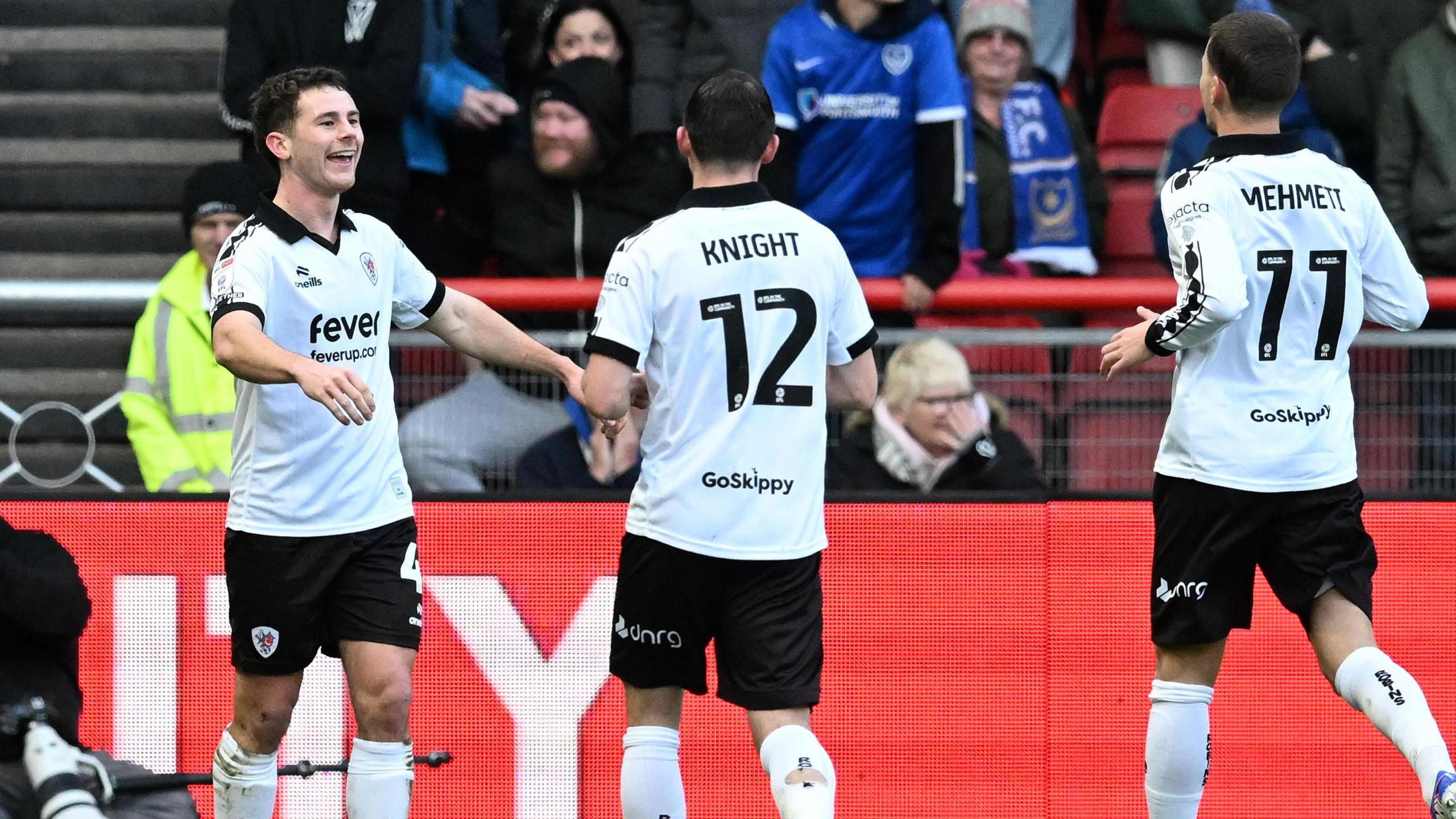 Adam Randell celebrates scoring for Bristol City with two of his teammates.
