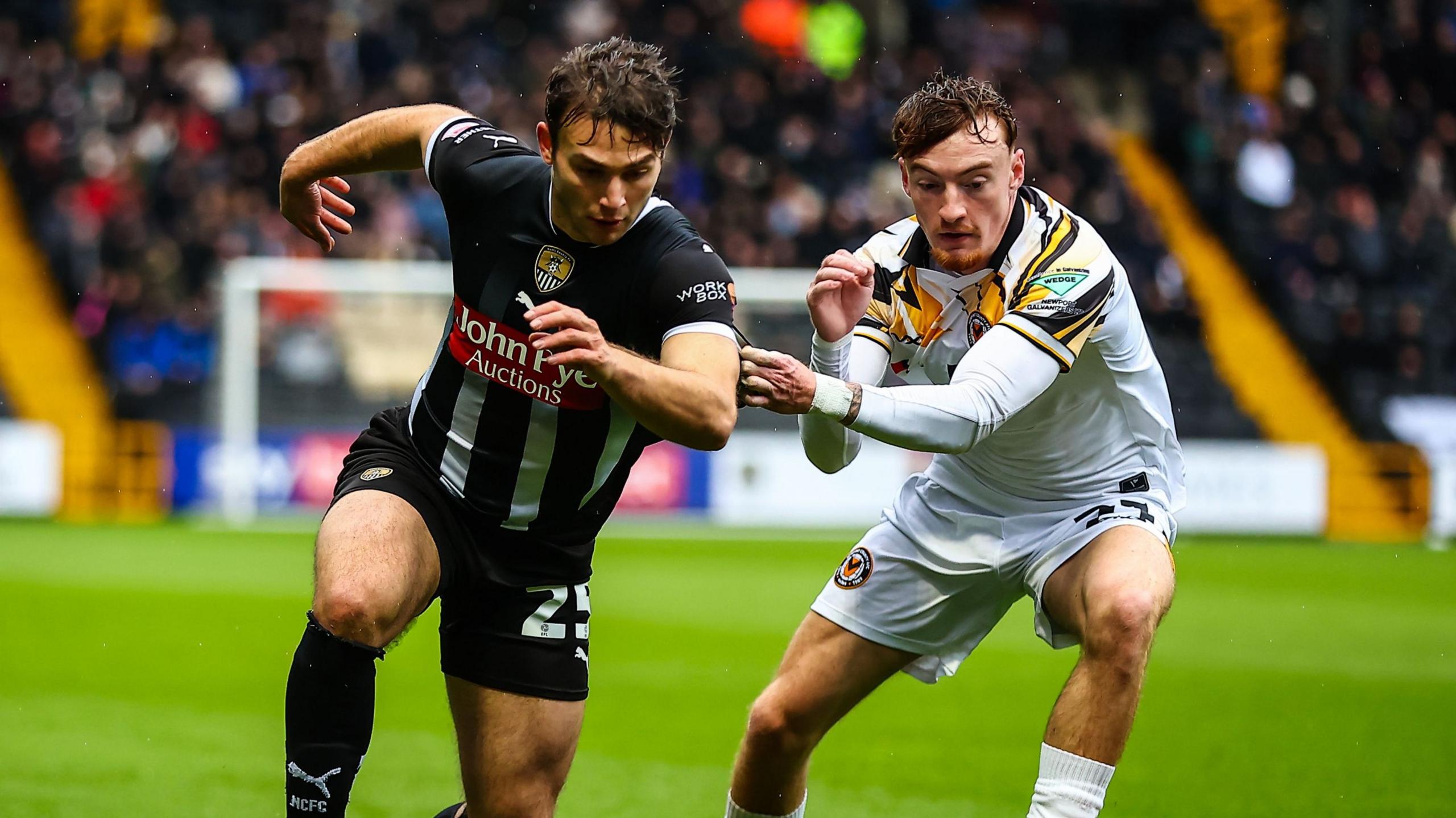 Nicholas Tsaroulla of Notts County feels pressure from Michael Spellman of Newport County

