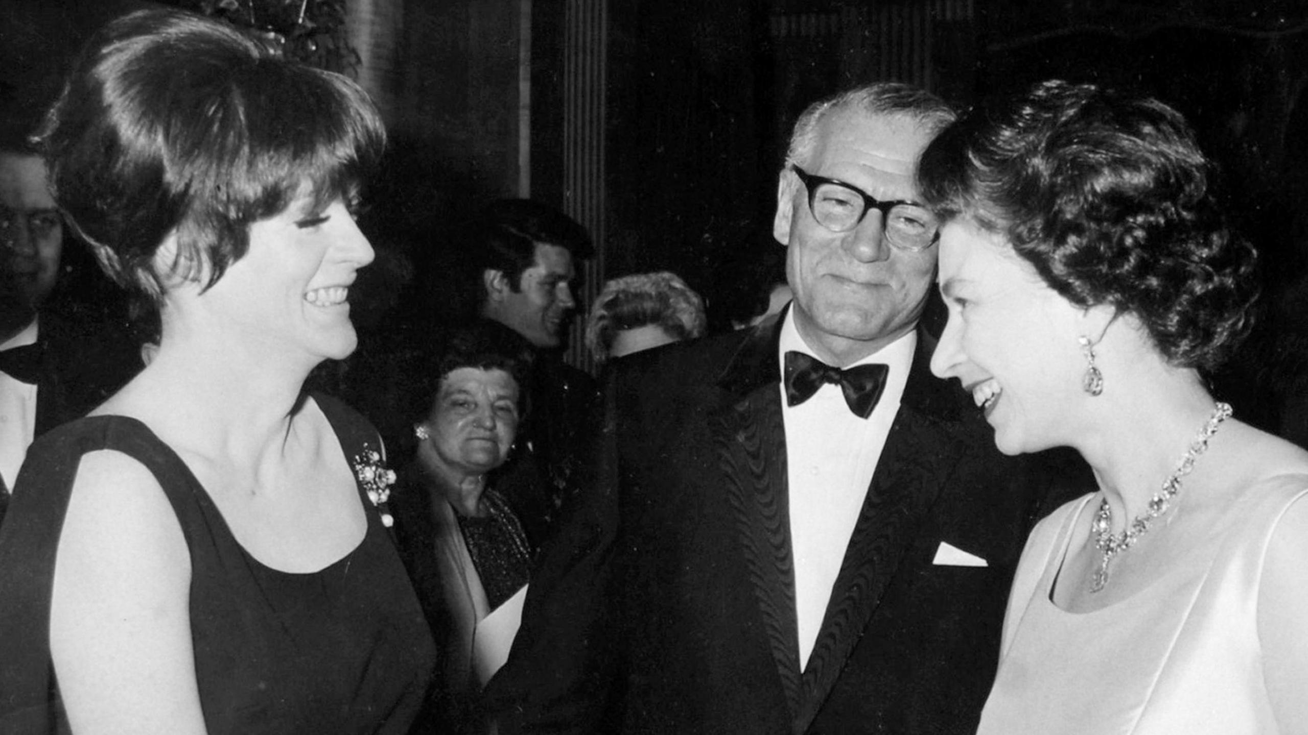 Queen Elizabeth II being presented to DameMaggie Smith by Sir Laurence Olivier, when the Queen attended the charity premiere of the film Othello at the Odeon Theatre in London in 1966 