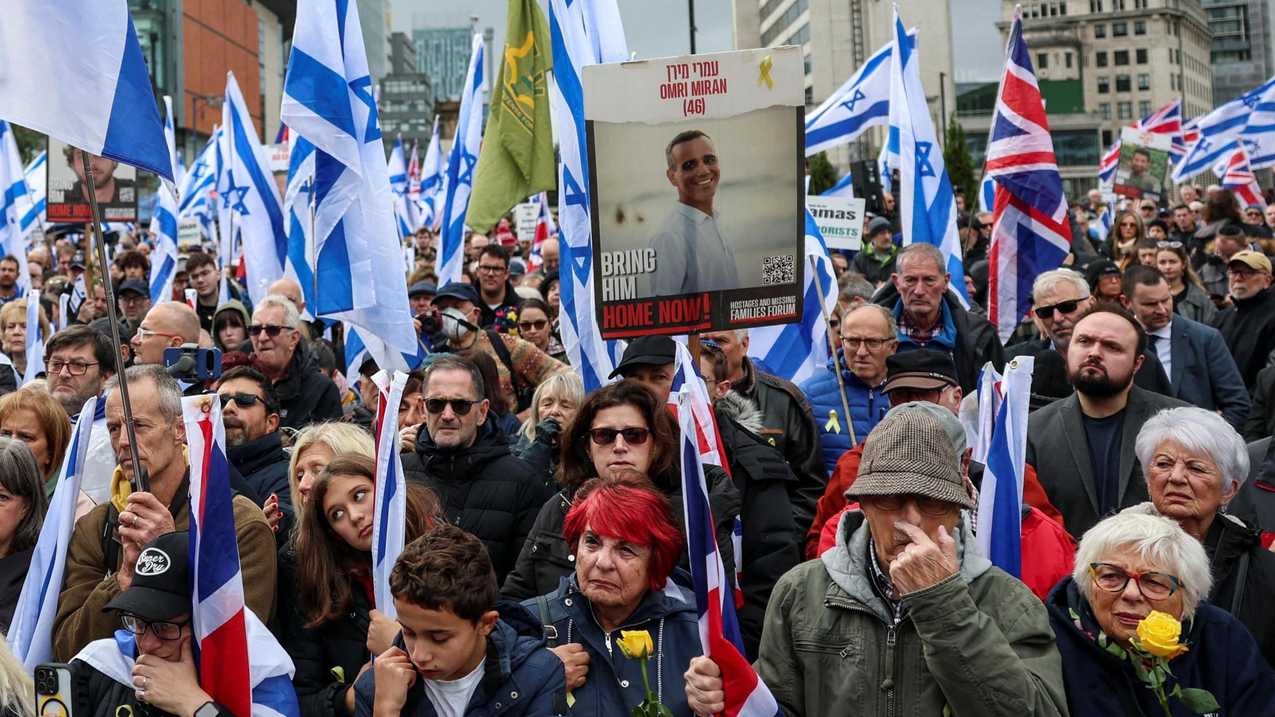 A large group of people holding Israeli and union jack flags.