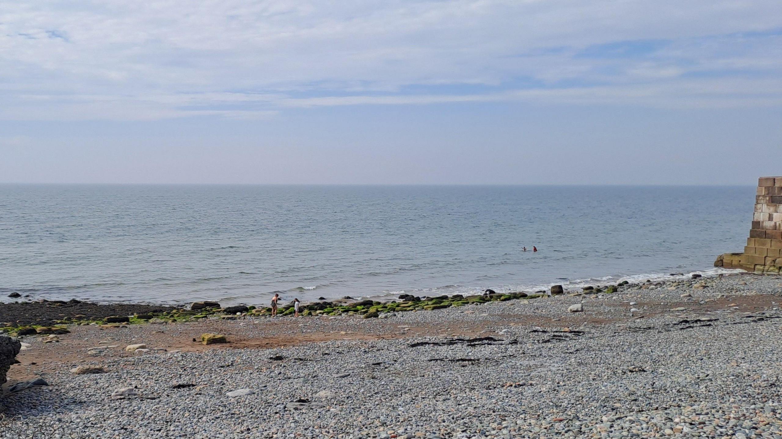 A general view of the beach at Harrington with some people swimming in the distance.