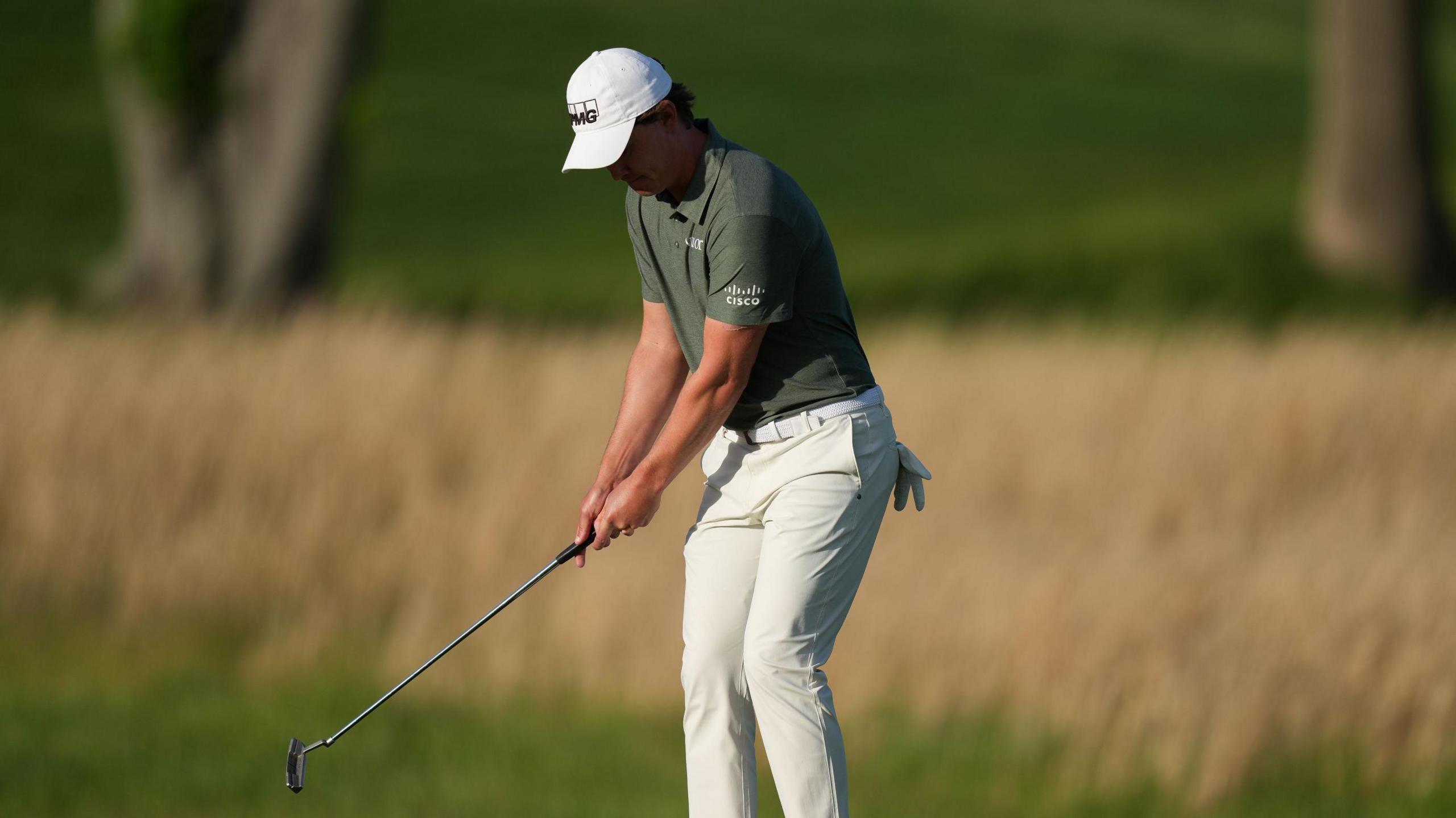 Maverick McNealy uses the toe of his putter to chip on to a green