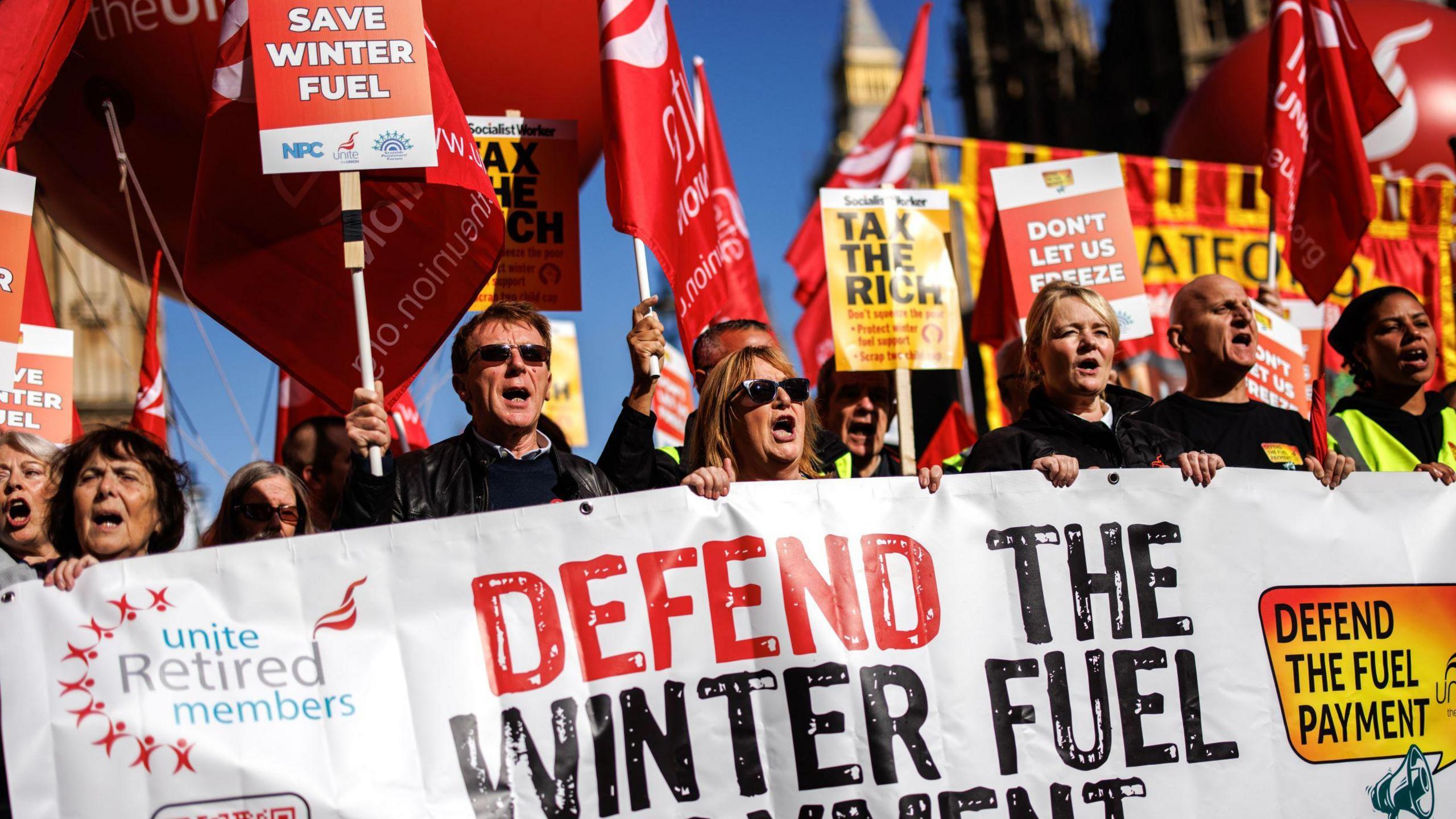 Protestors gathered outside the House of Commons to protest against the winter fuel payment decision, waving placards and holding banners and signs saying "defend the fuel payment", "don't let us freeze" and "tax the rich" 