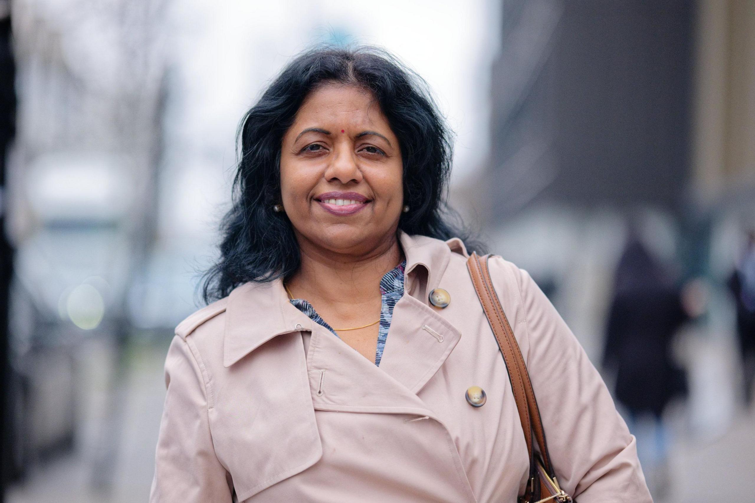 Meera Jeyakumar is standing in the centre of Croydon and smiles towards the camera