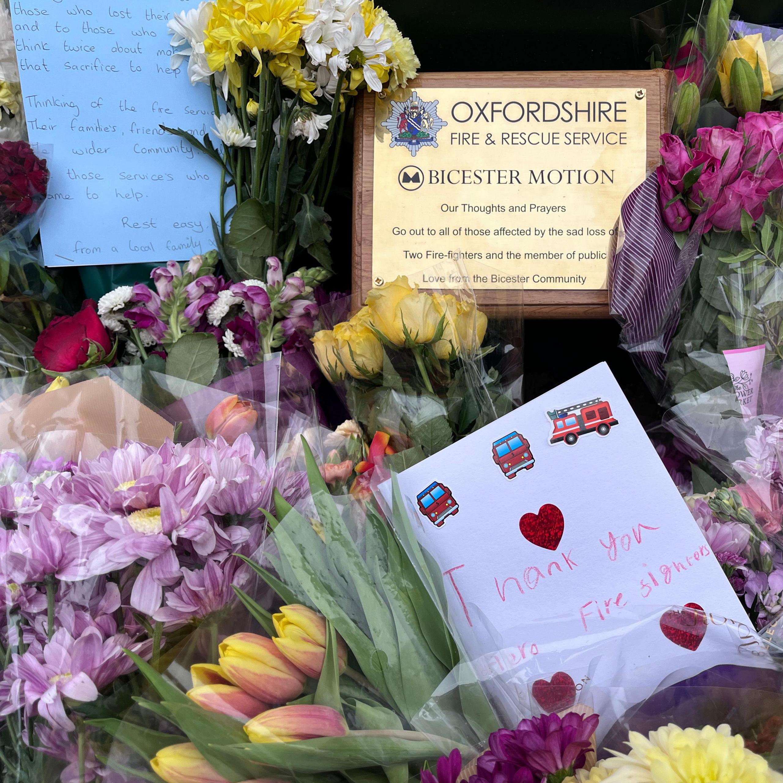 Bunches of flowers, with plaque and cards among them.