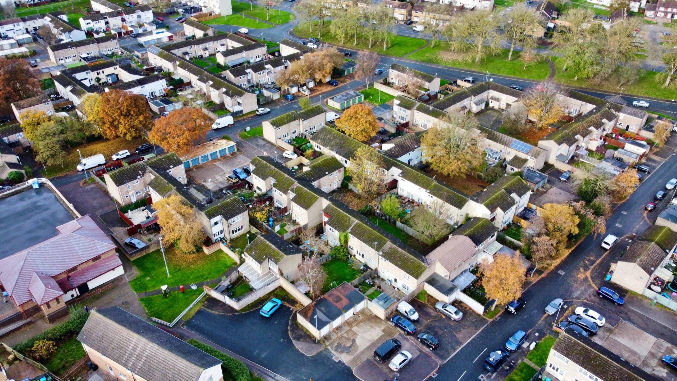 A drone shot showing an elevated view of houses and flats on the Lincoln estate in Corby. The rows of flats are tightly hemmed together by walkways with roads only visible around the edge of the estate. 