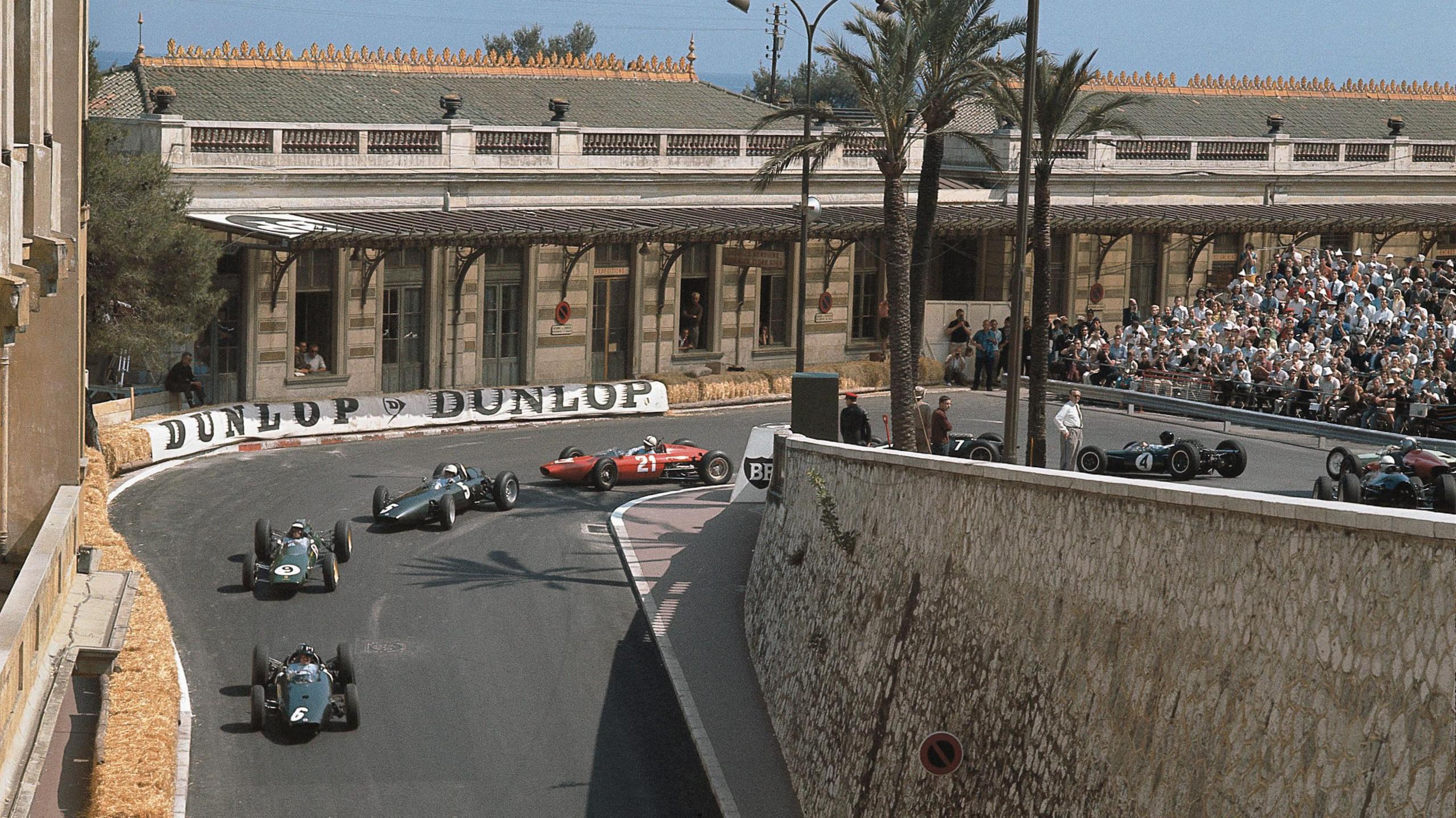 Graham Hill leads Jim Clark in the early stages of the 1963 Monaco Grand Prix, as a train of cars come through the hairpin